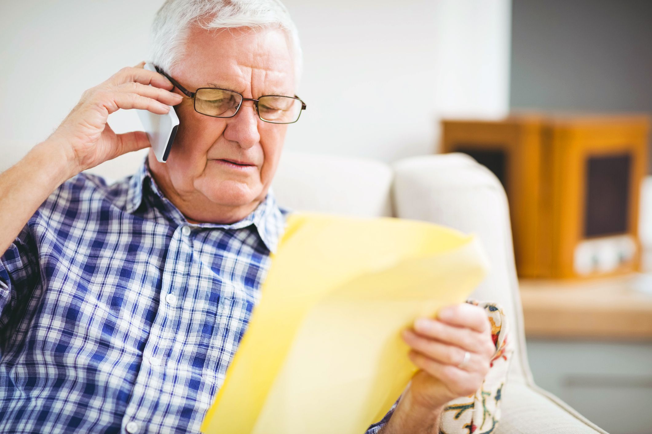 senior man on the phone holding documents