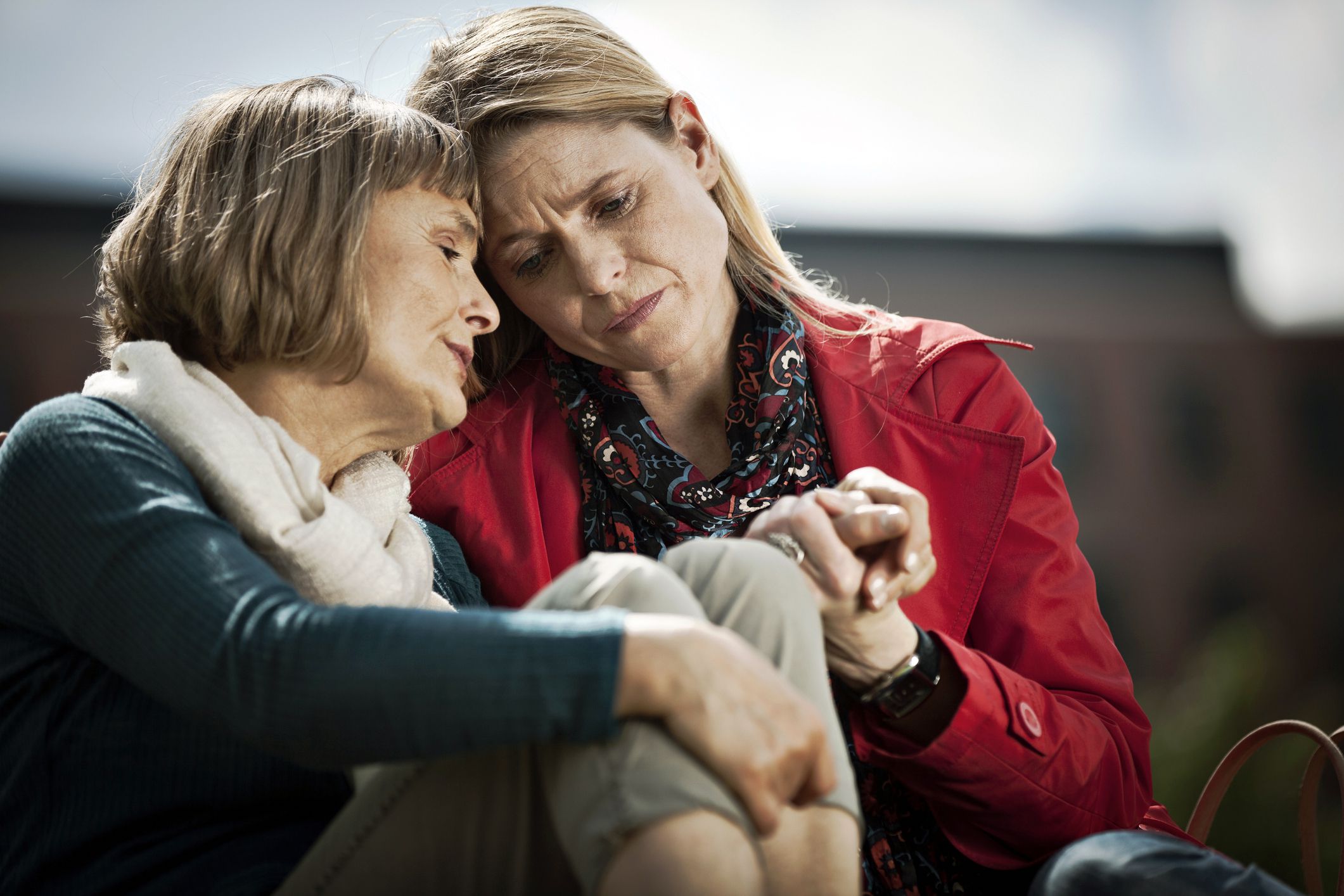 elderly woman being comforted by middle-aged woman