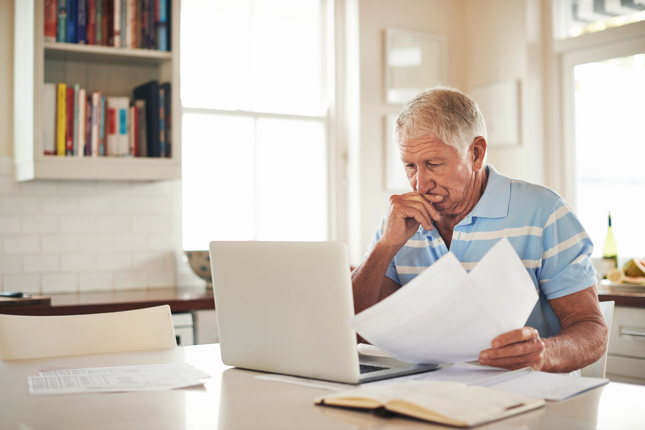 elderly man looking at computer screen indoors