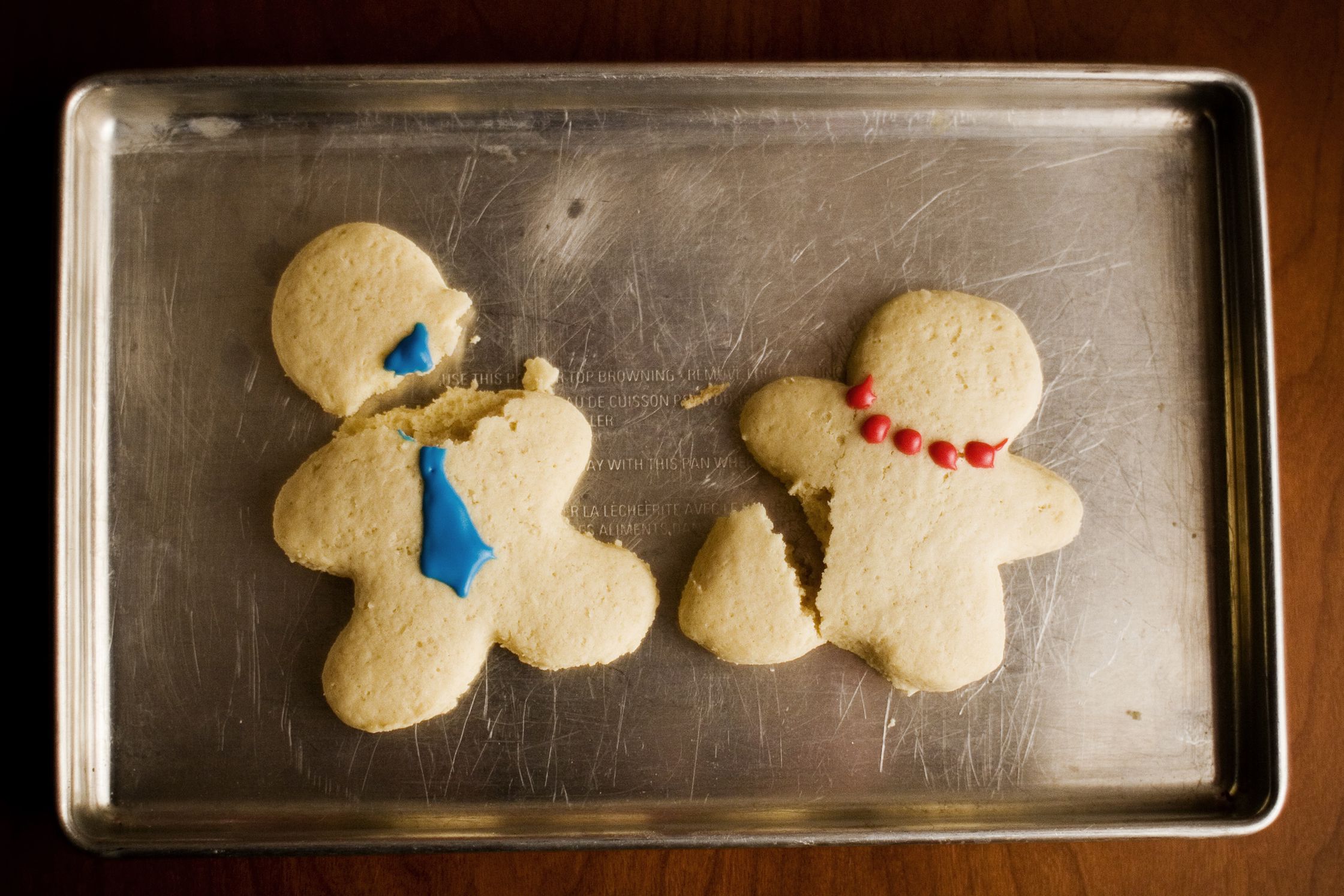 broken christmas cookies on tray on wooden surface