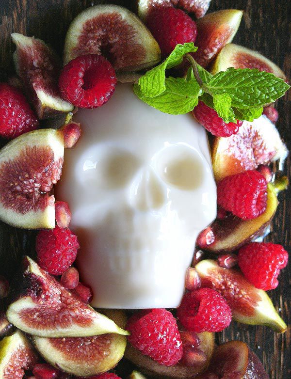suga skull surrounded by figs raspberries and pomegranate seeds