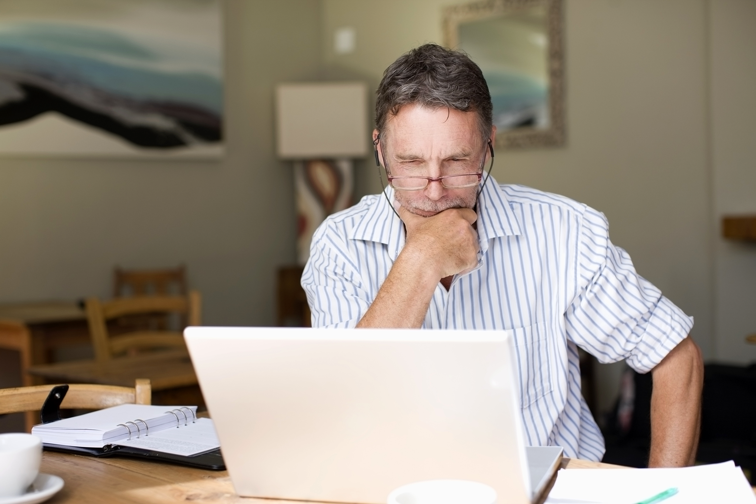 Man looking at his computer and looking unsure