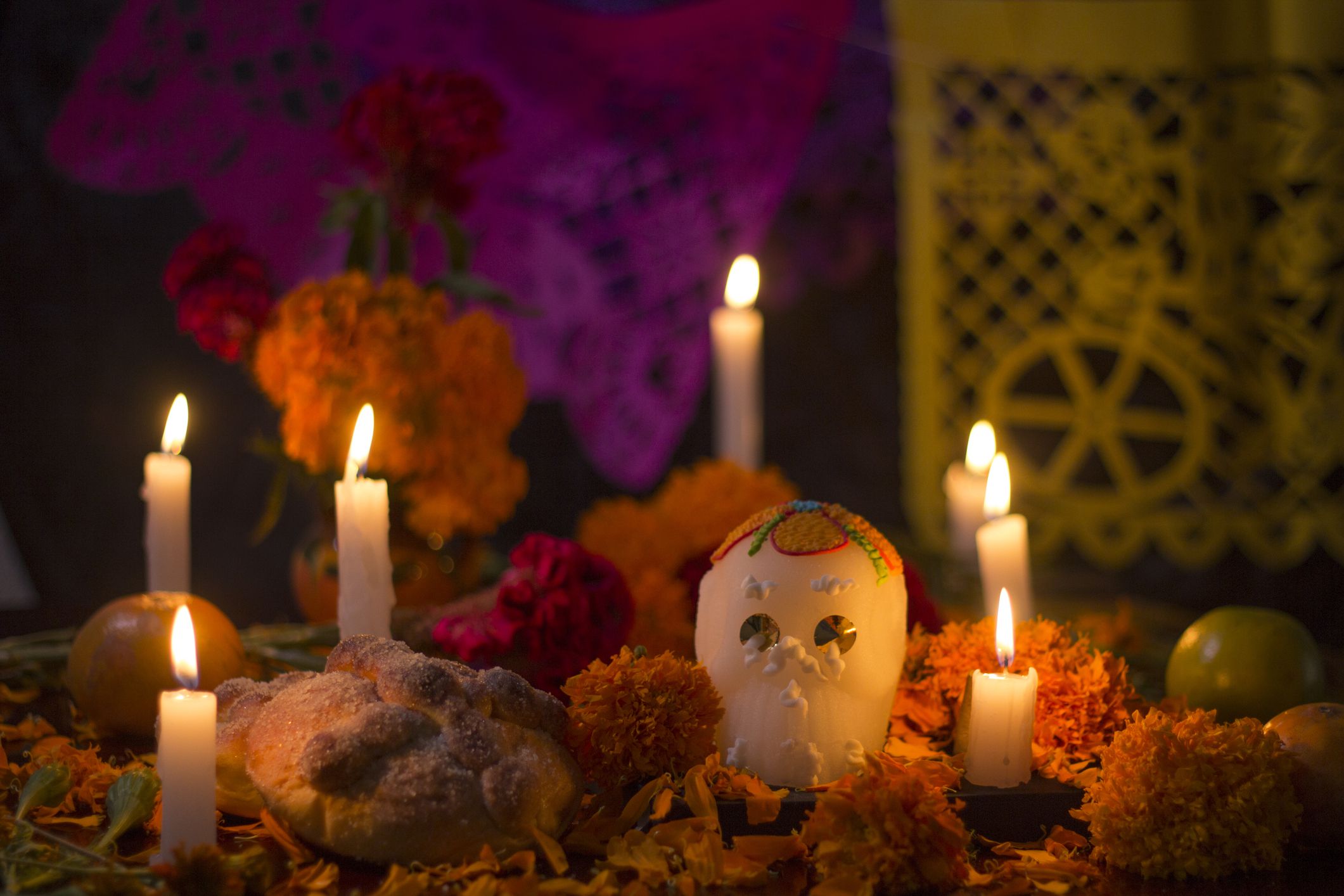 Traditional altar for day of the day celebration with sugar skull, bread, yellow cempasuchil flowers and candle light