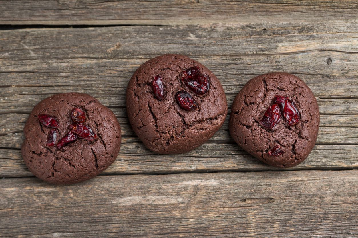 chocolate cranberry cookies on wooden surface