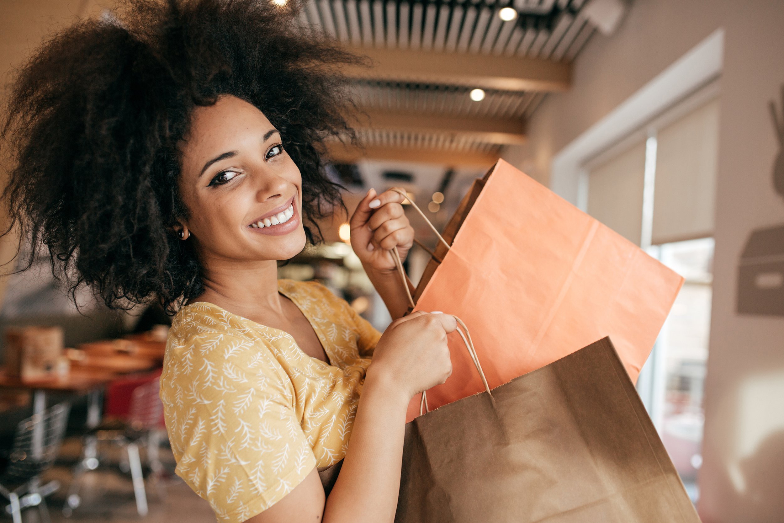 Happy woman leaving store with shopping bags