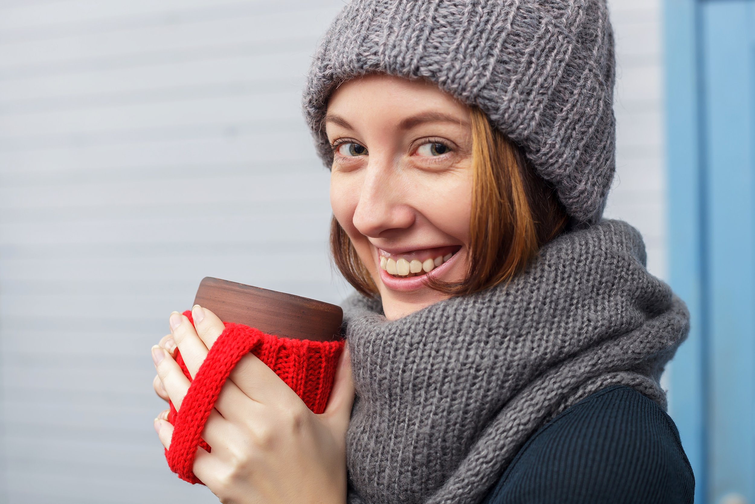 Closeup of woman wearing winter clothing and drinking coffee