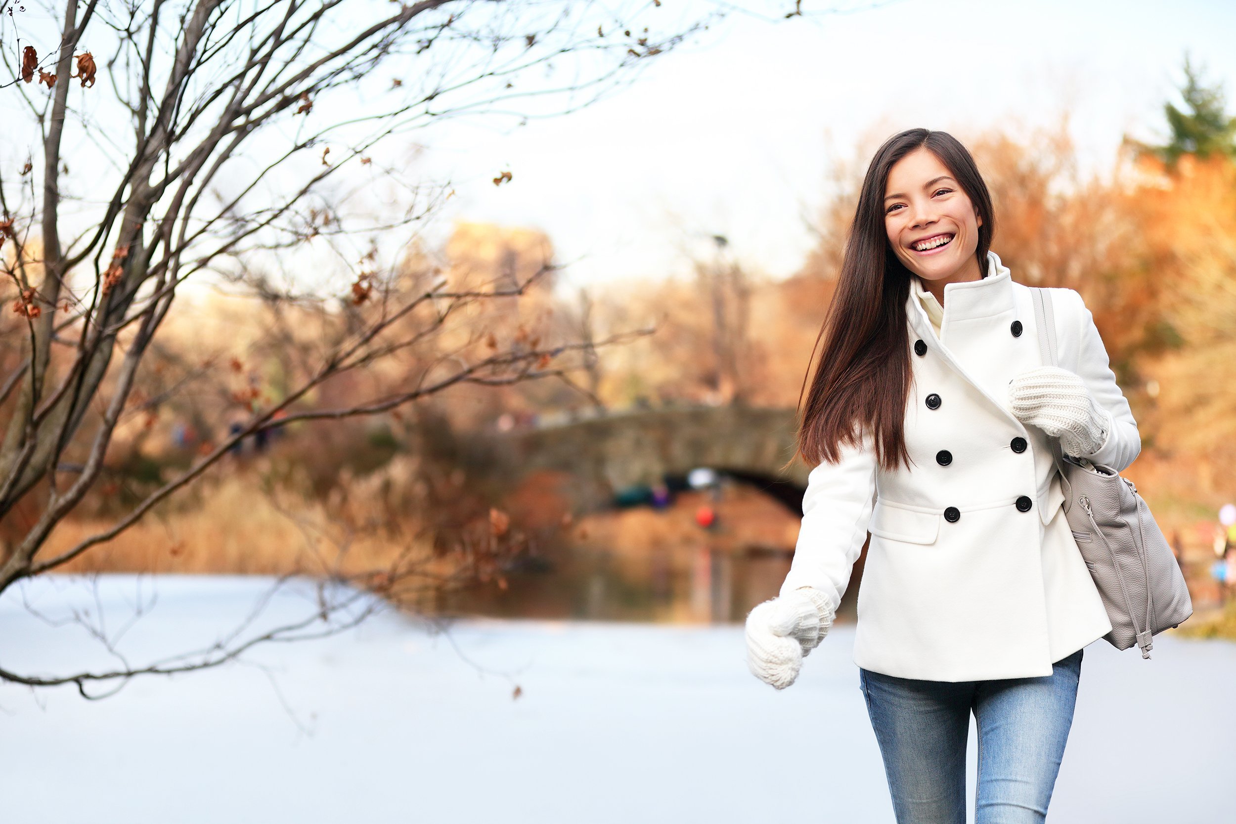 happy woman walking in Central park, New York City in late fall