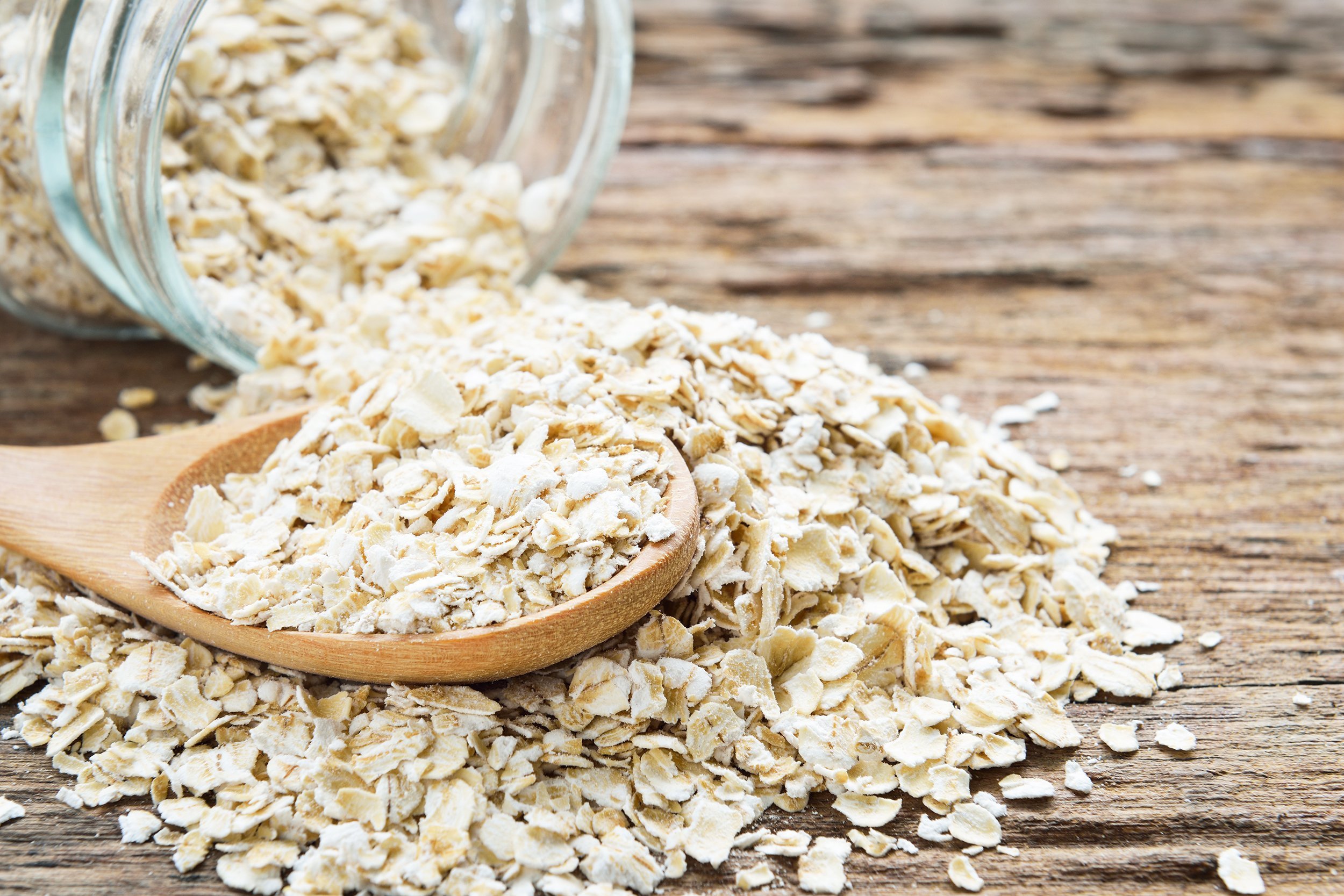 dry rolled oat flakes oatmeal on old wooden table
