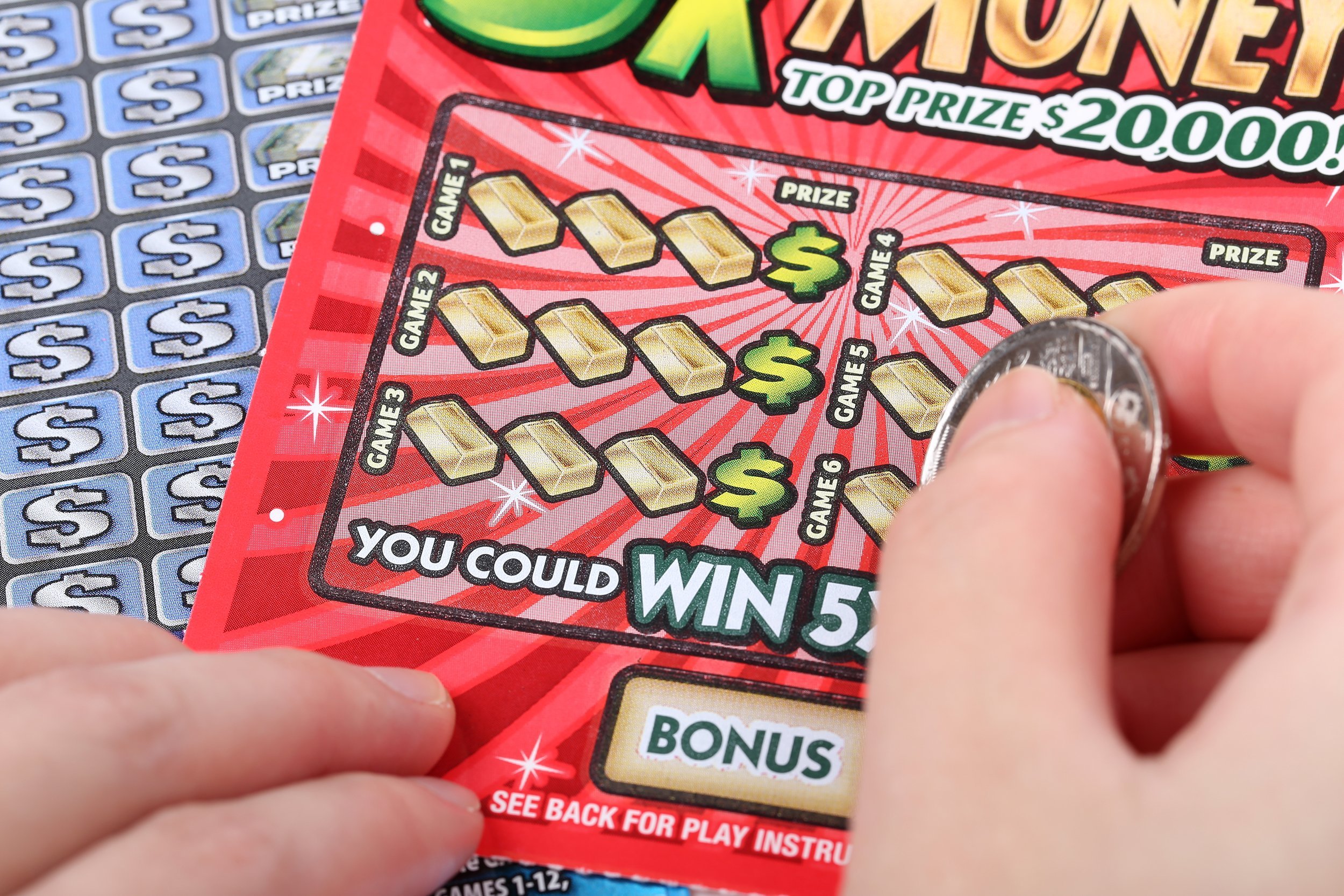 Hand scratching off a lottery ticket