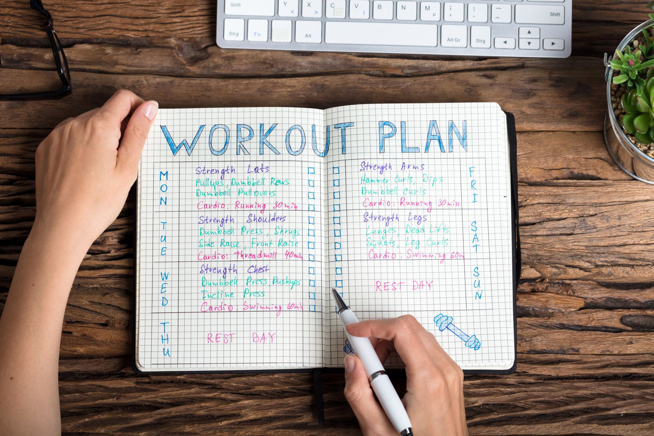 exercise journal open on wooden surface, marker in hand