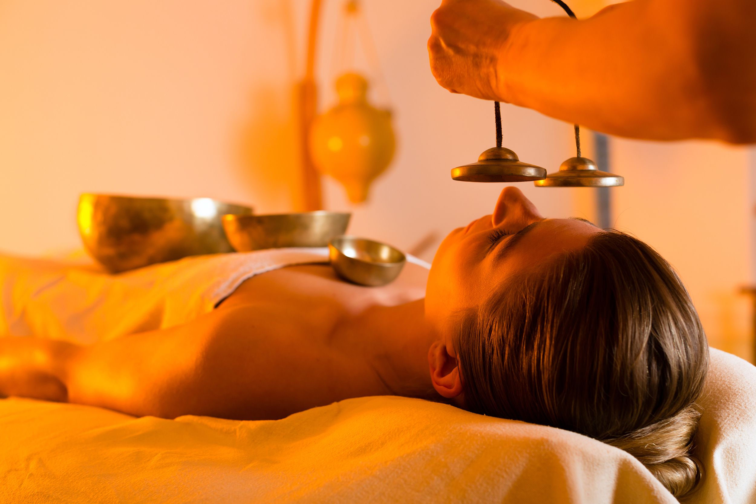 woman at wellness massage with singing bowls