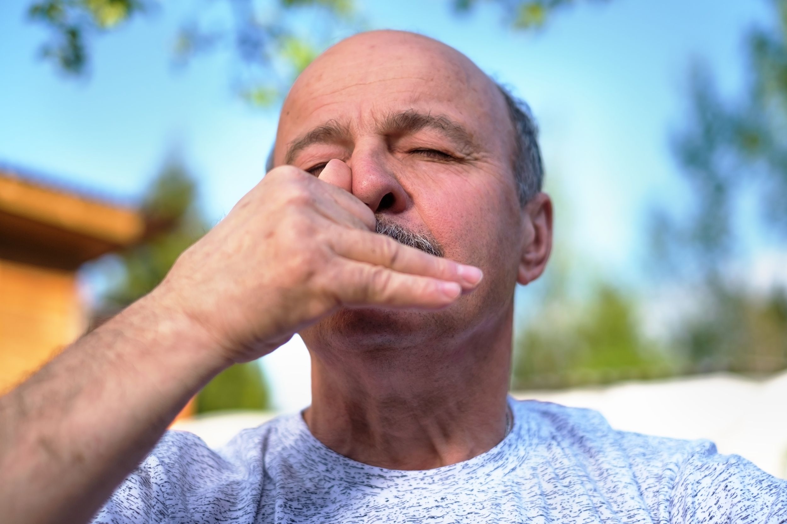 mature man breathing yoga pranayama on summer sunny day outside