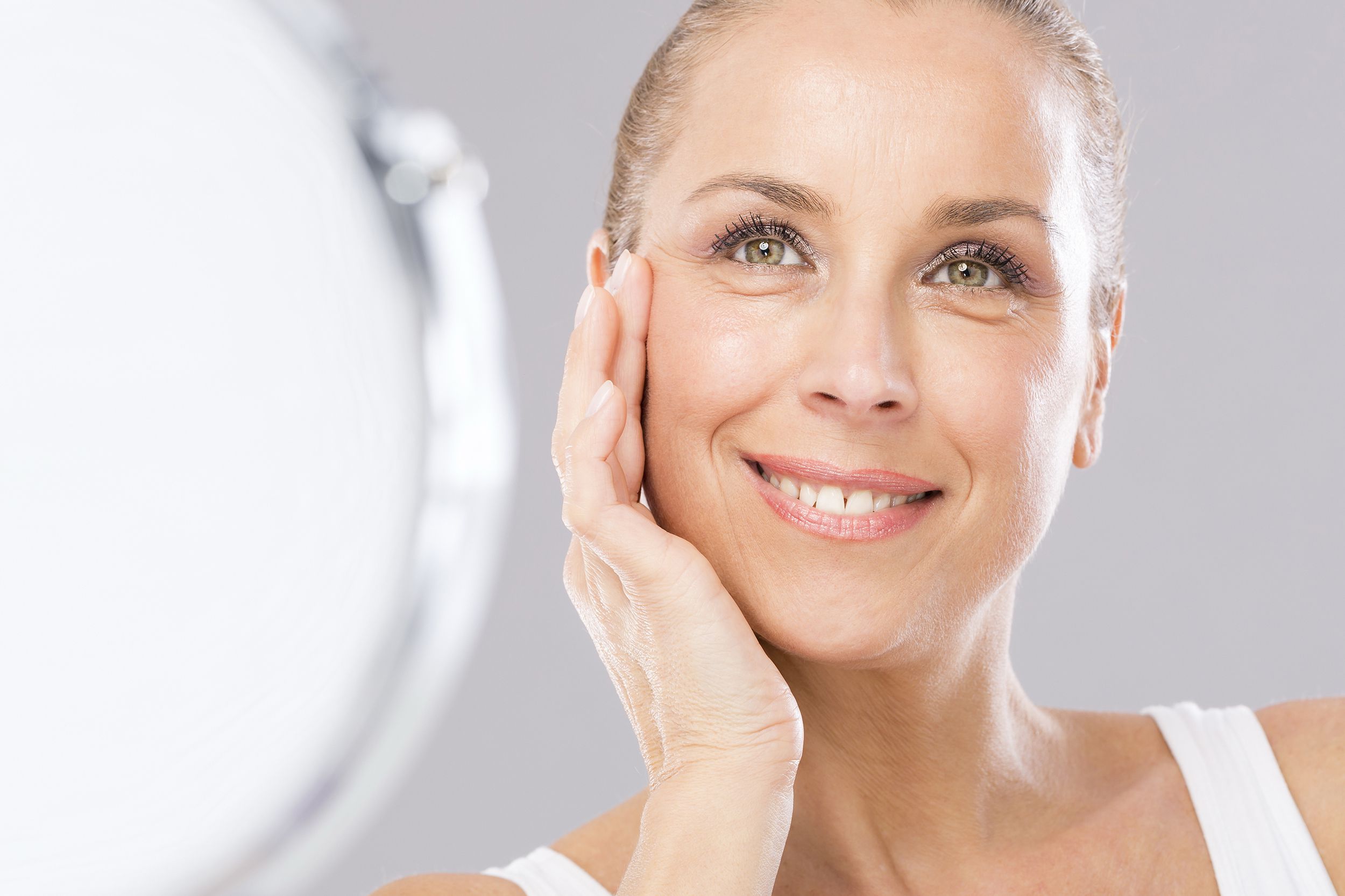 beautiful woman smiling while looking in the mirror