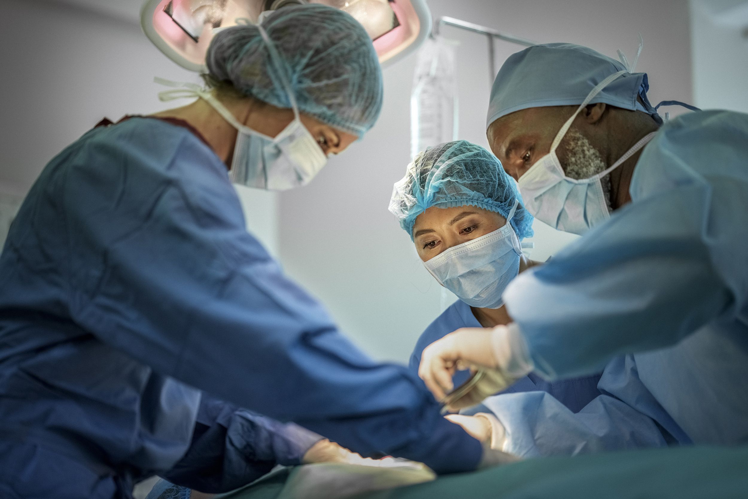 multi-ethnic doctors operating girl at hospital