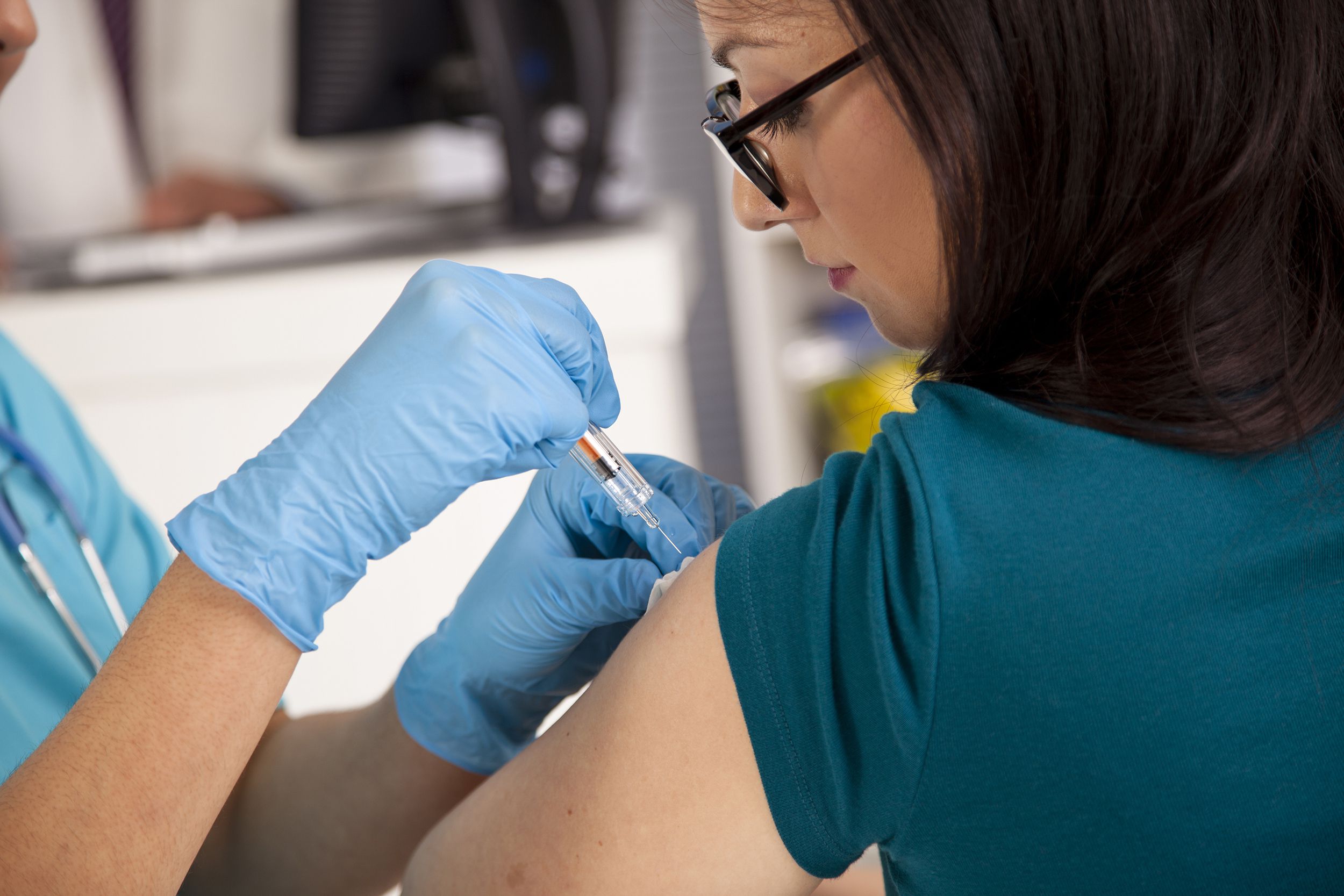 nurse at clinic giving shot to patient