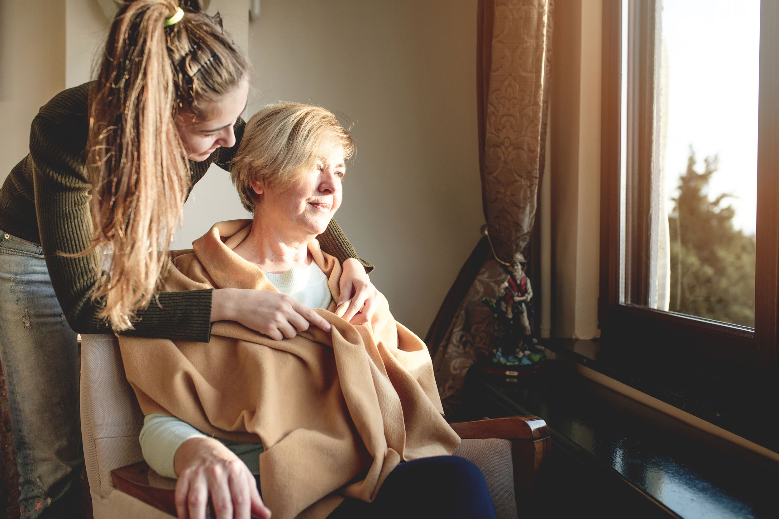 daughter caring for elderly mom in wheelchair