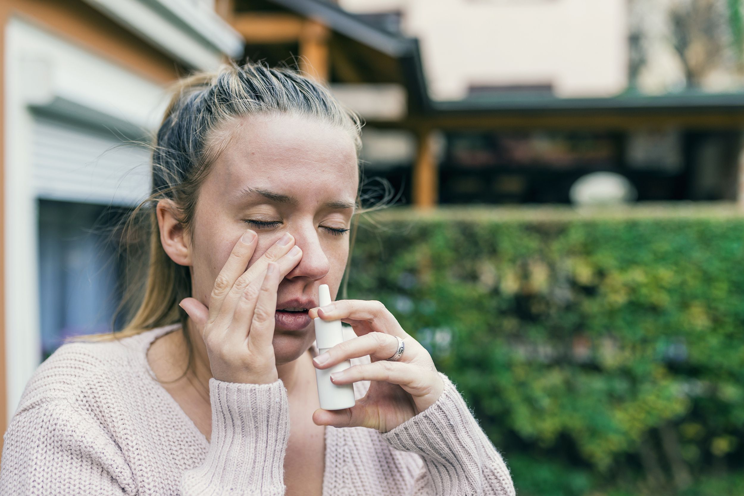 woman taking nasal spray outside