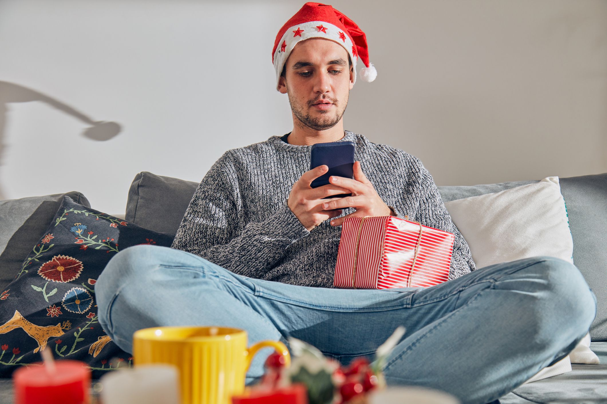 man in christmas hat texting