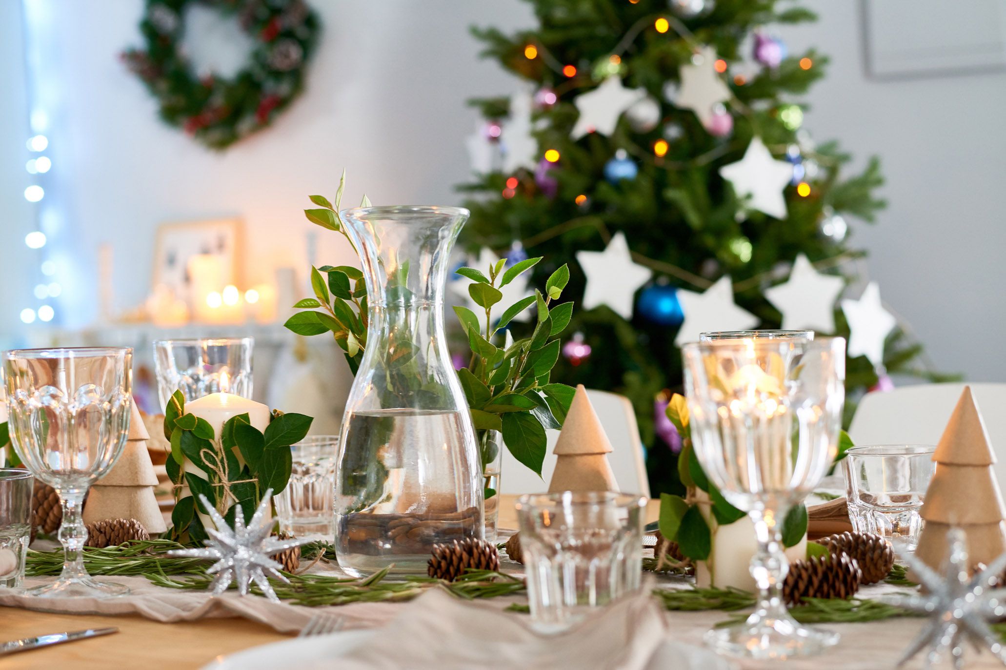 water pitcher and glasses on table in front of christmas tree