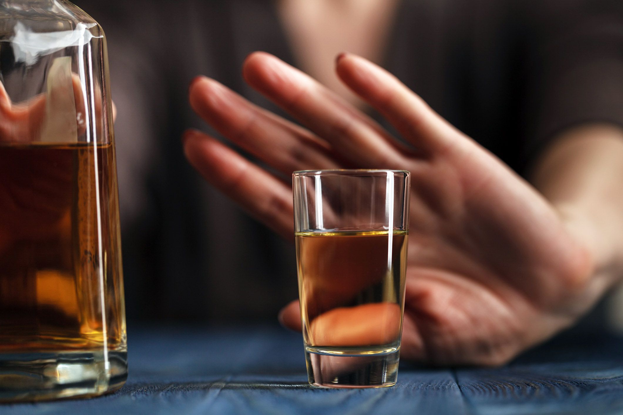 hand saying no to bottle of liquor