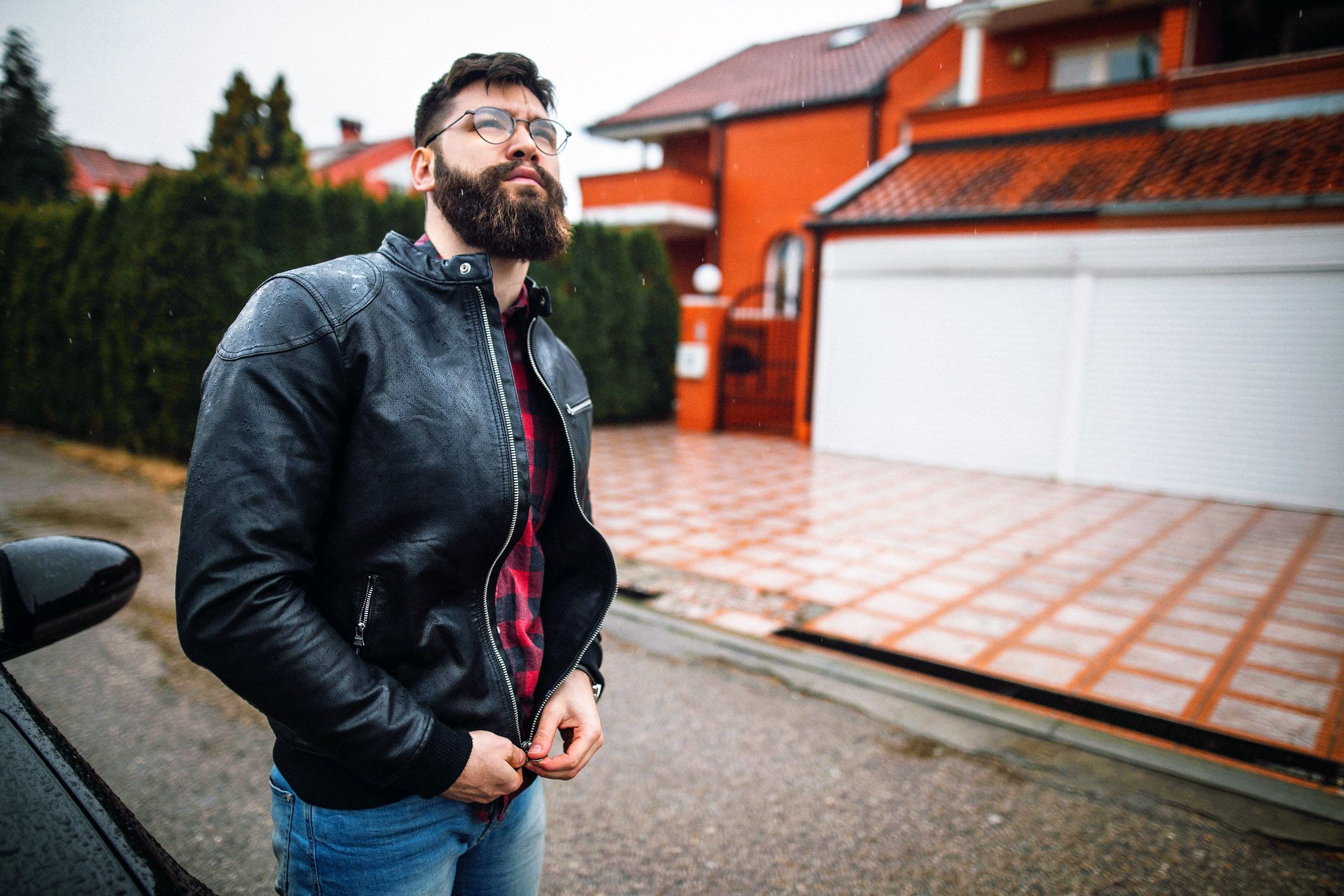 man outdoors zipping leather jacket
