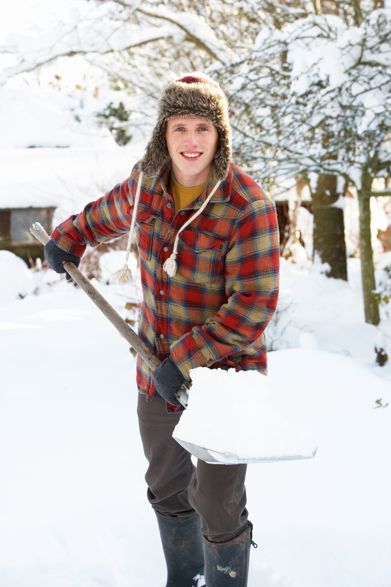 young man clearing snow in driving