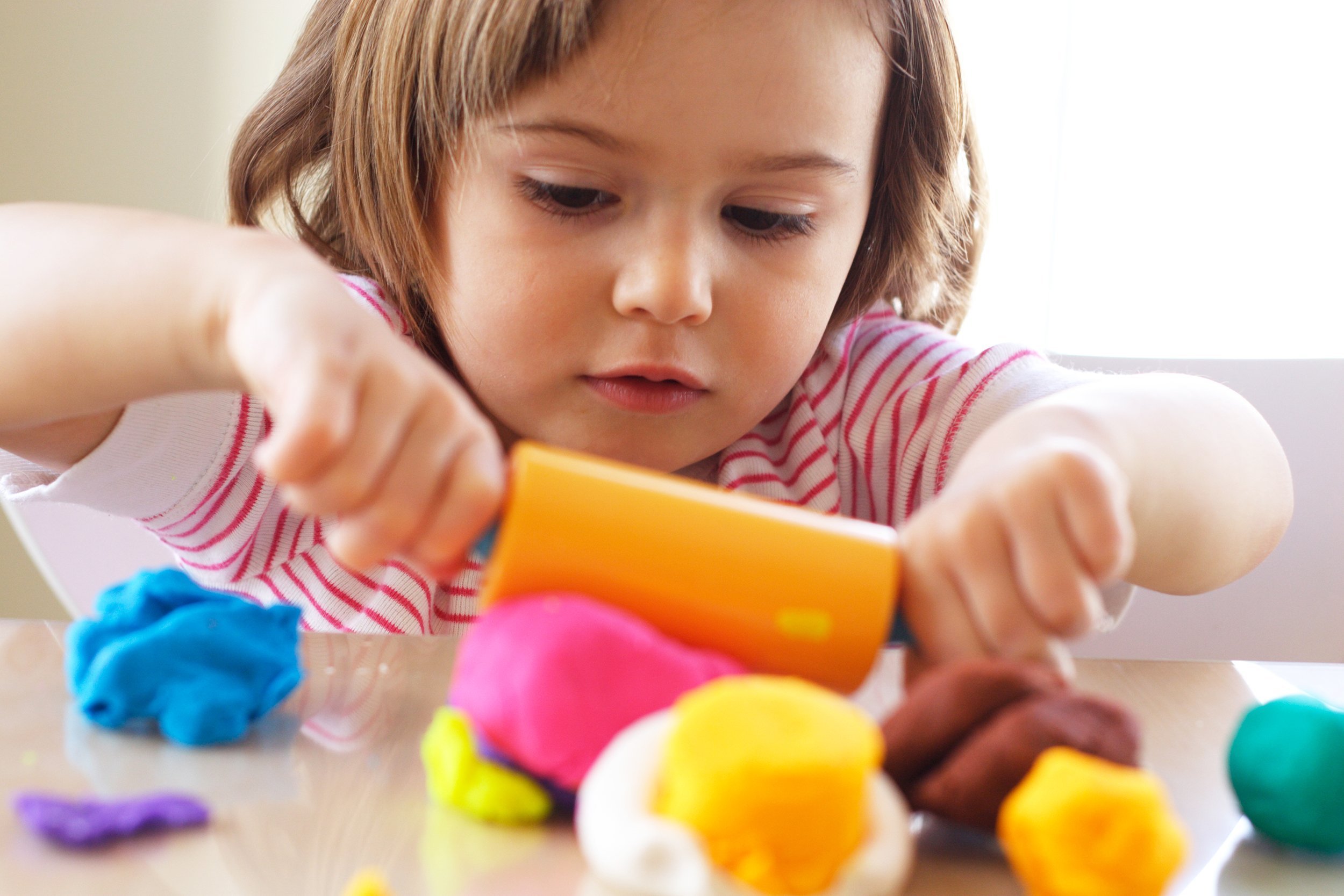 little girl creating toys from play dough