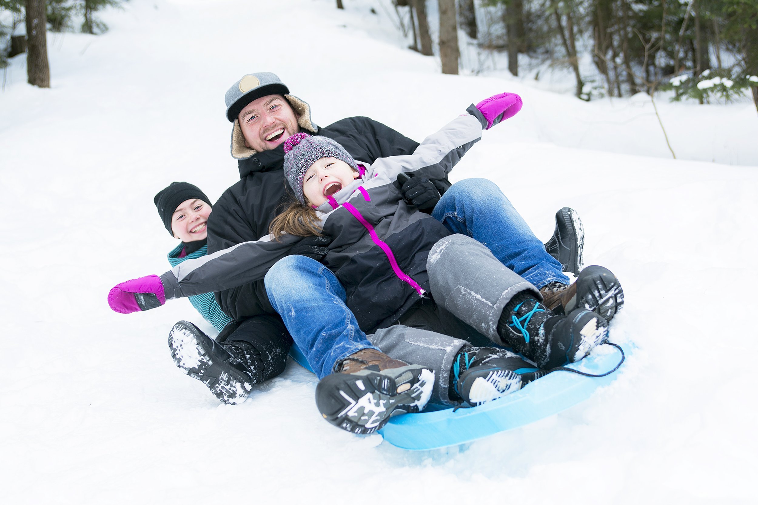father and son sledding at winter time
