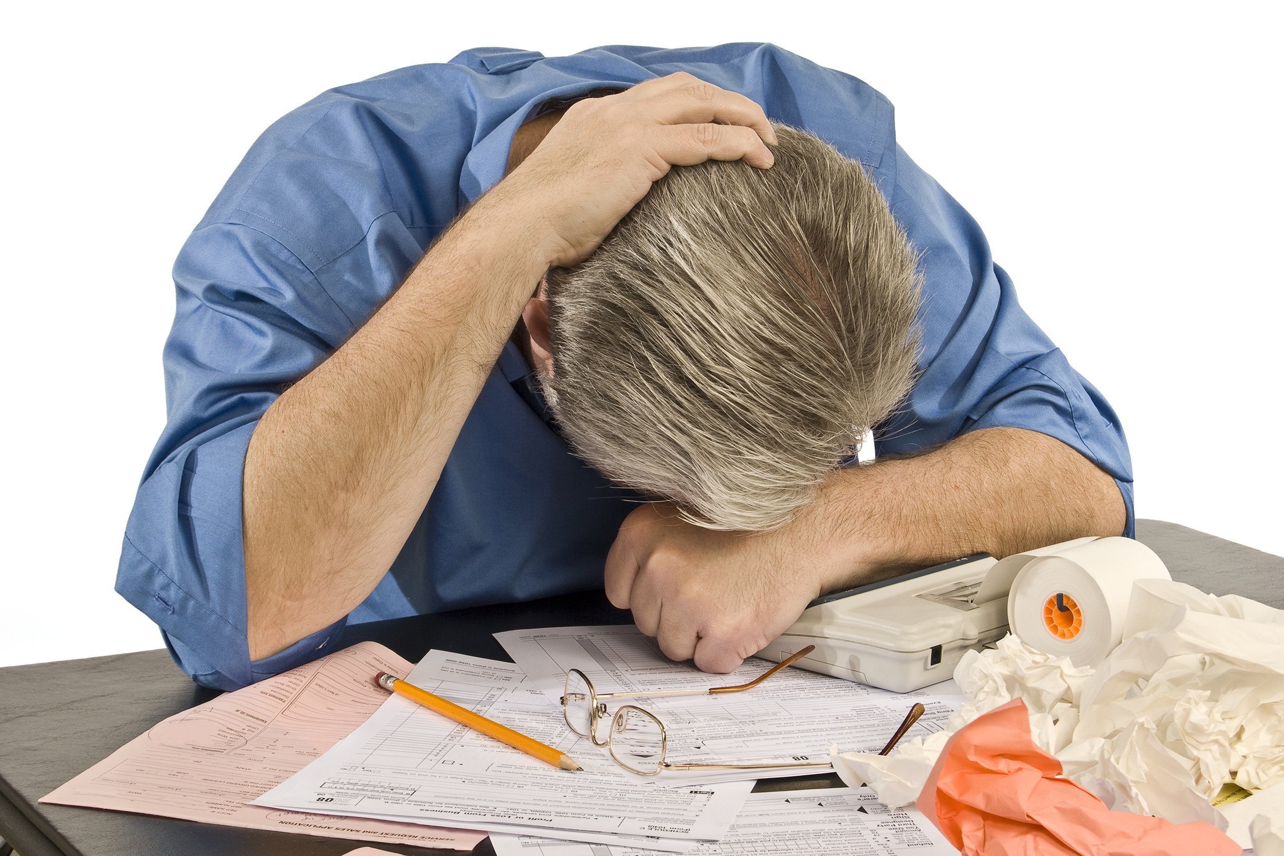 man sitting over tax paperwork with troubles