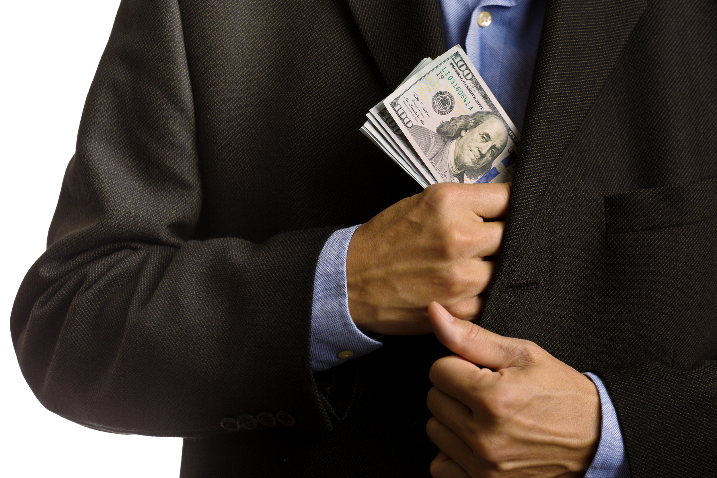 Businessman putting money in his suit jacket