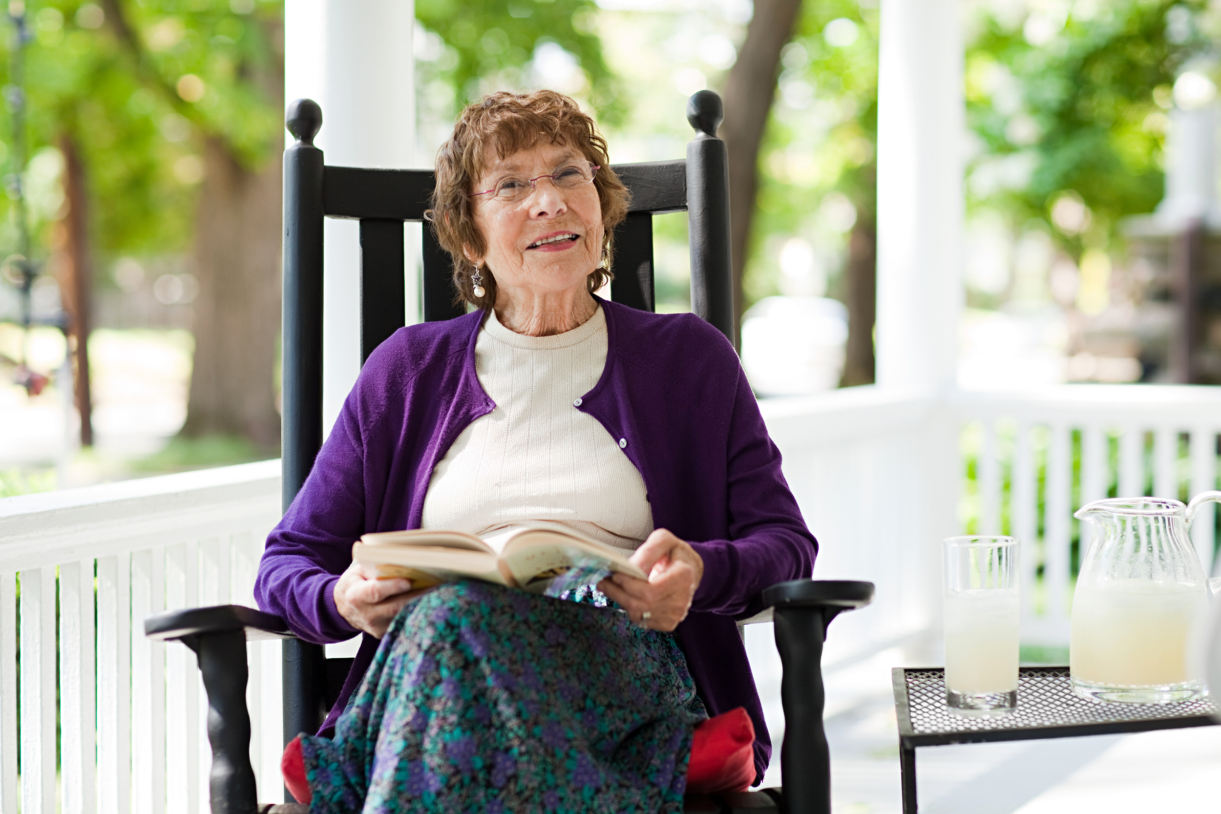 Old woman on a rocking chair on her porch