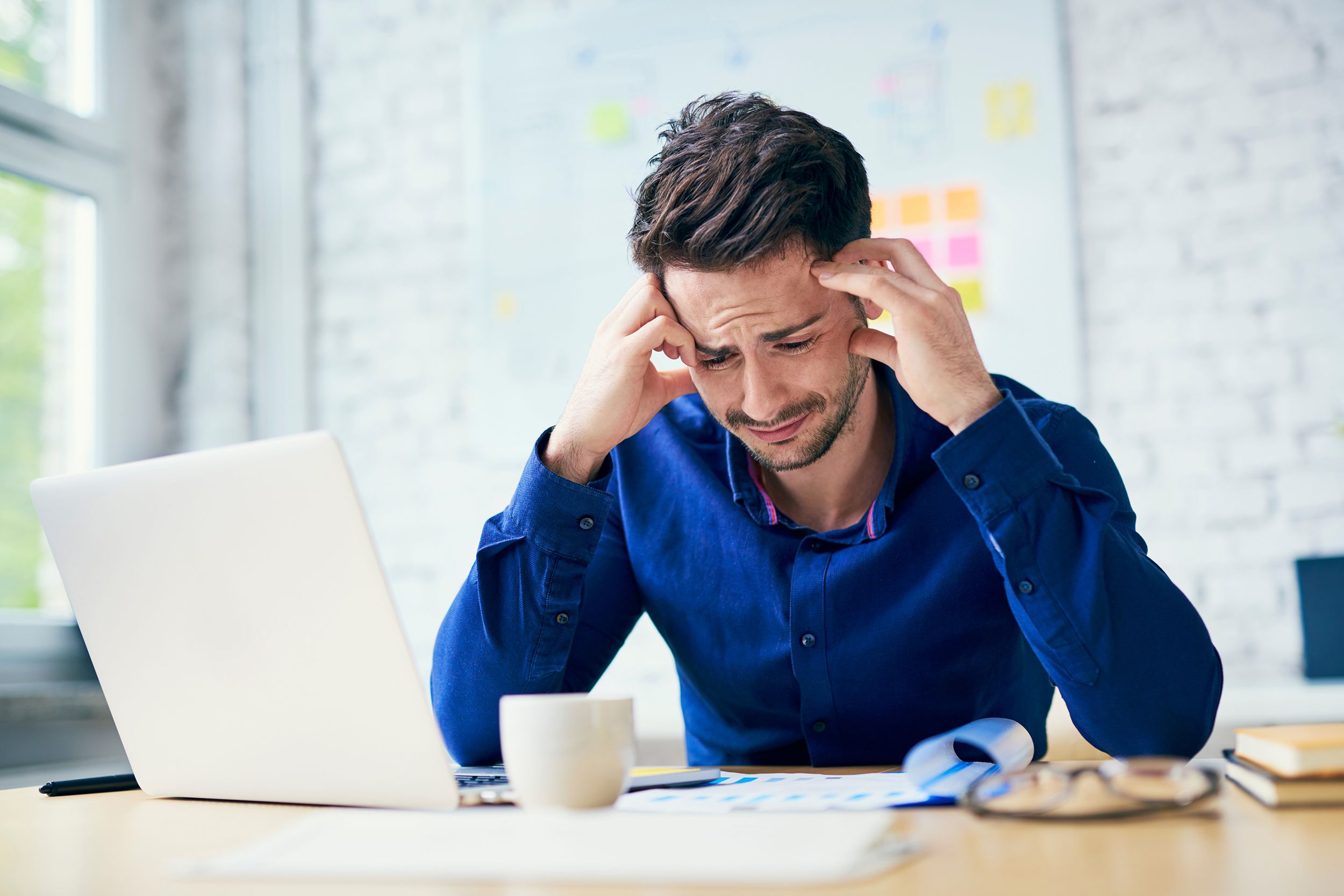stressed man in office looking on documents