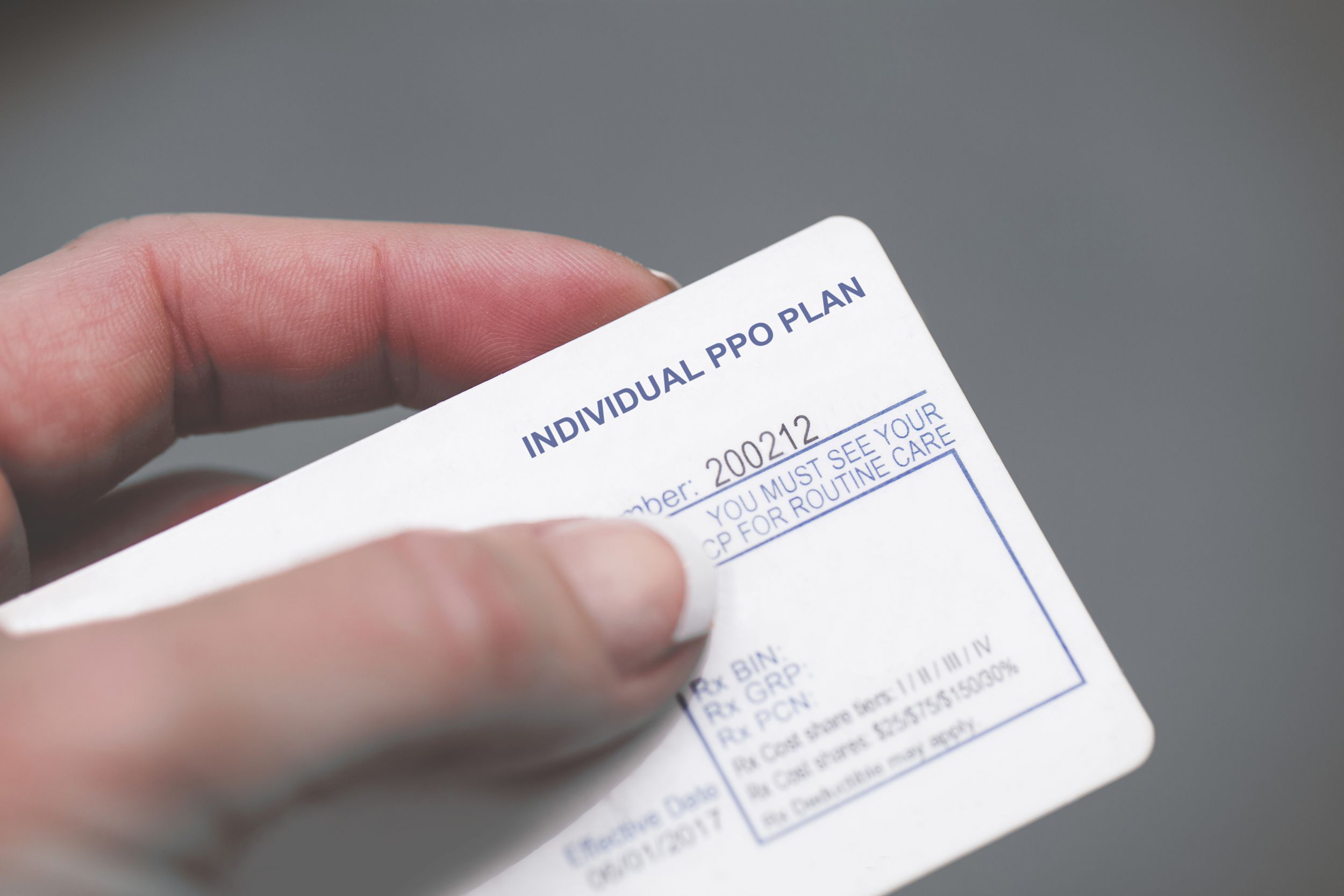 hand holding health insurance card
