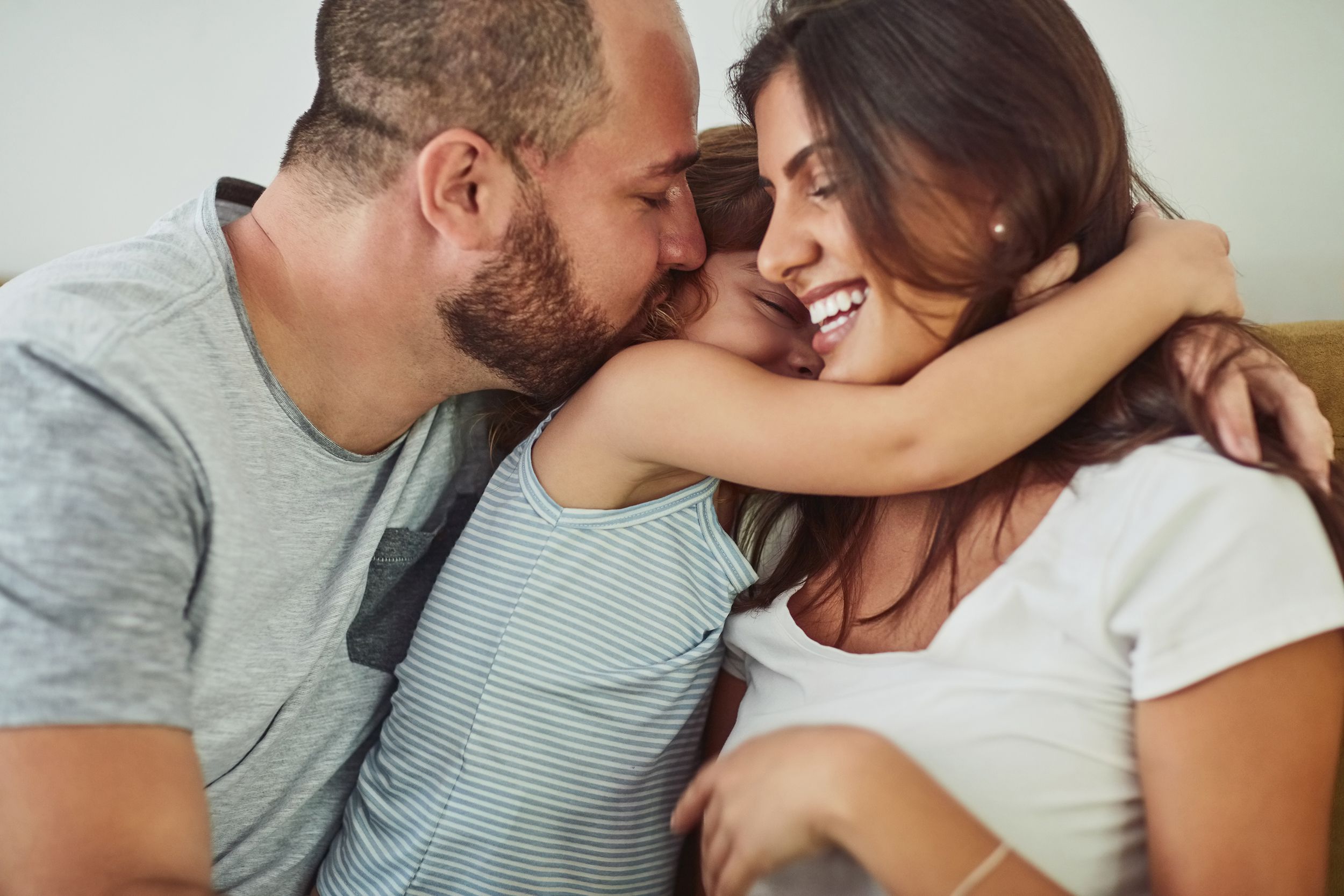 couple hugging their child