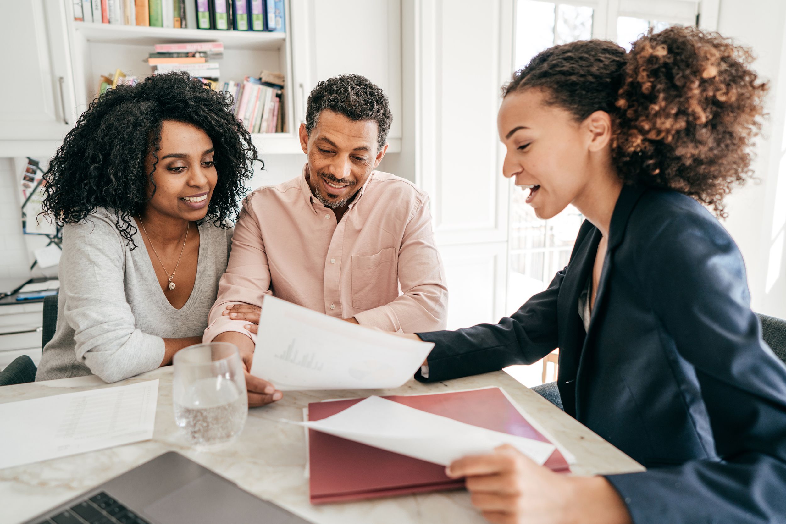 insurance agent going over policy at home of a couple