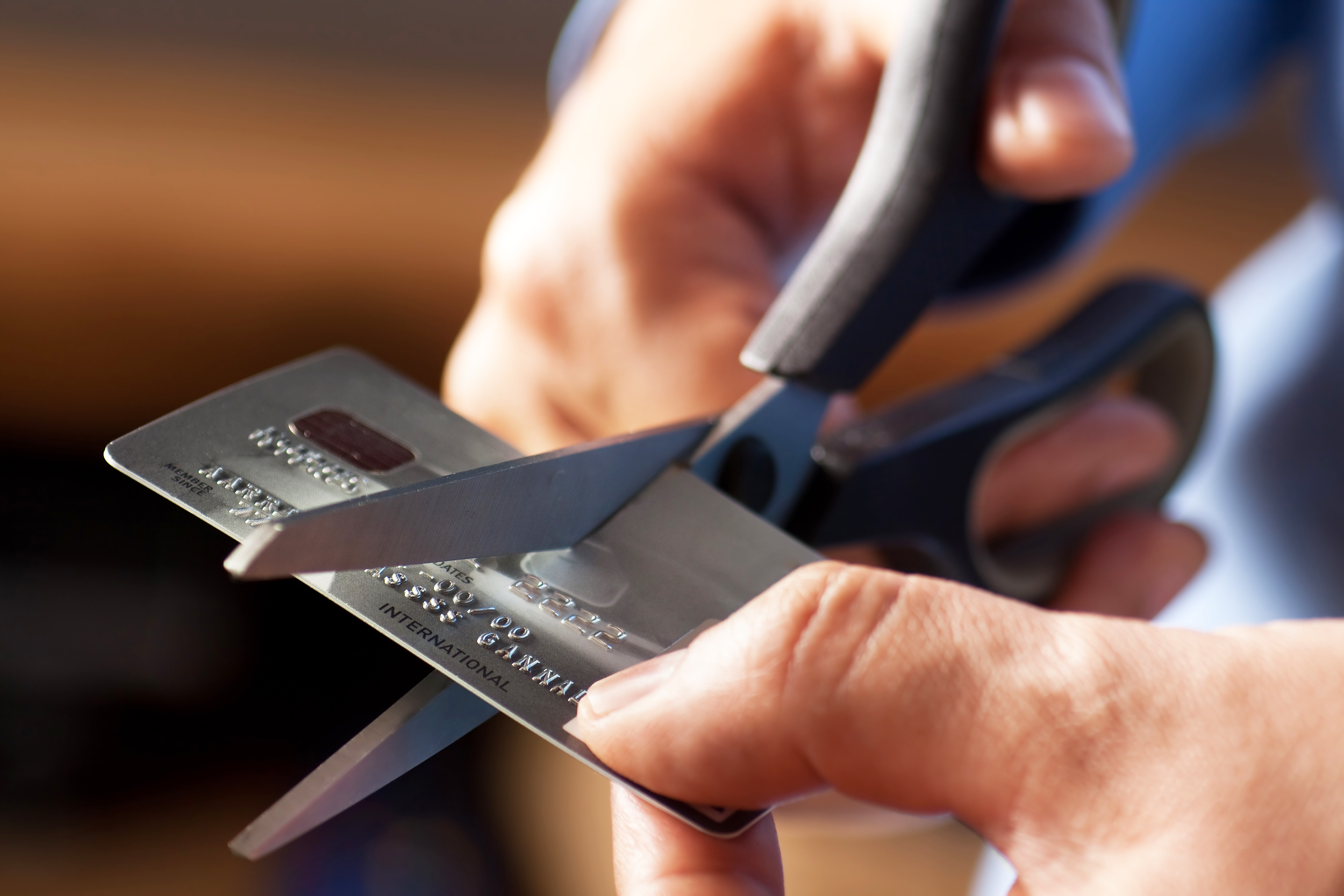 Man cutting credit card with scissors