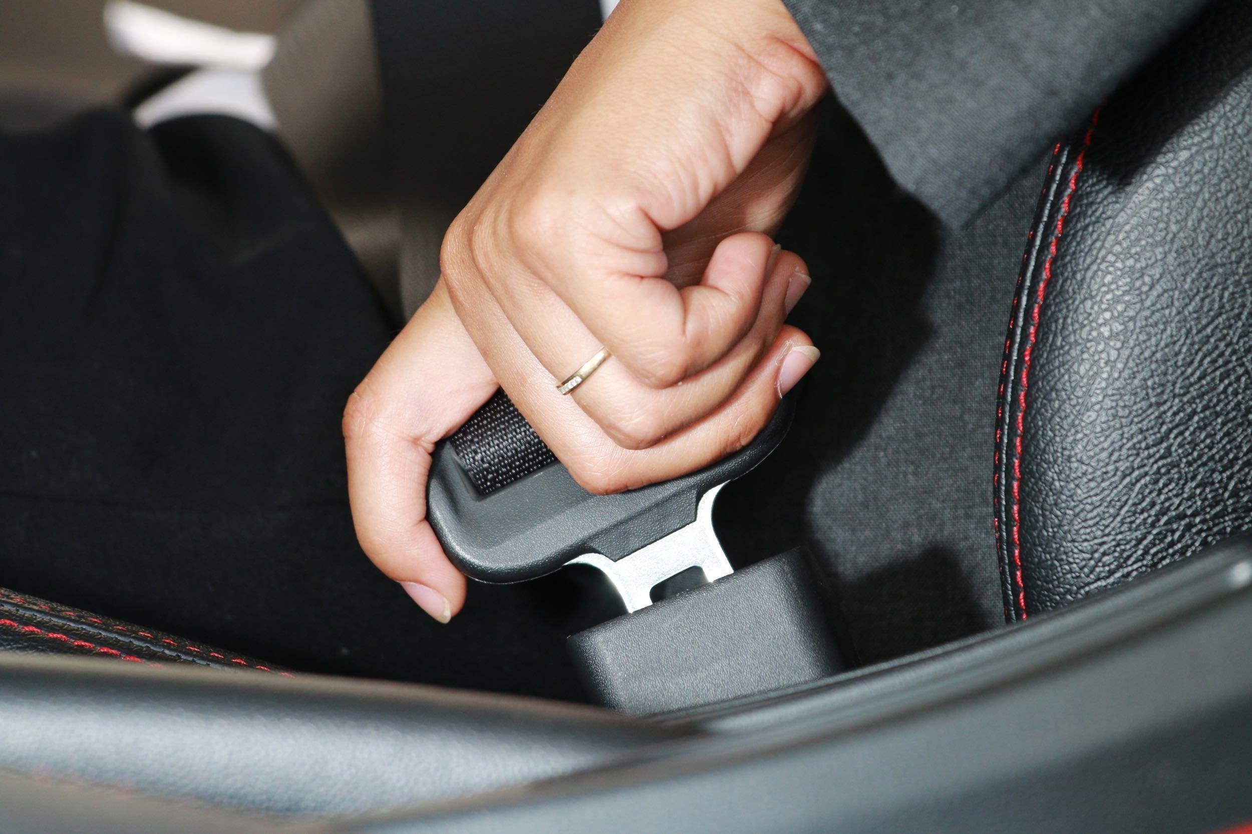 business woman hand fastening a seat belt in the car