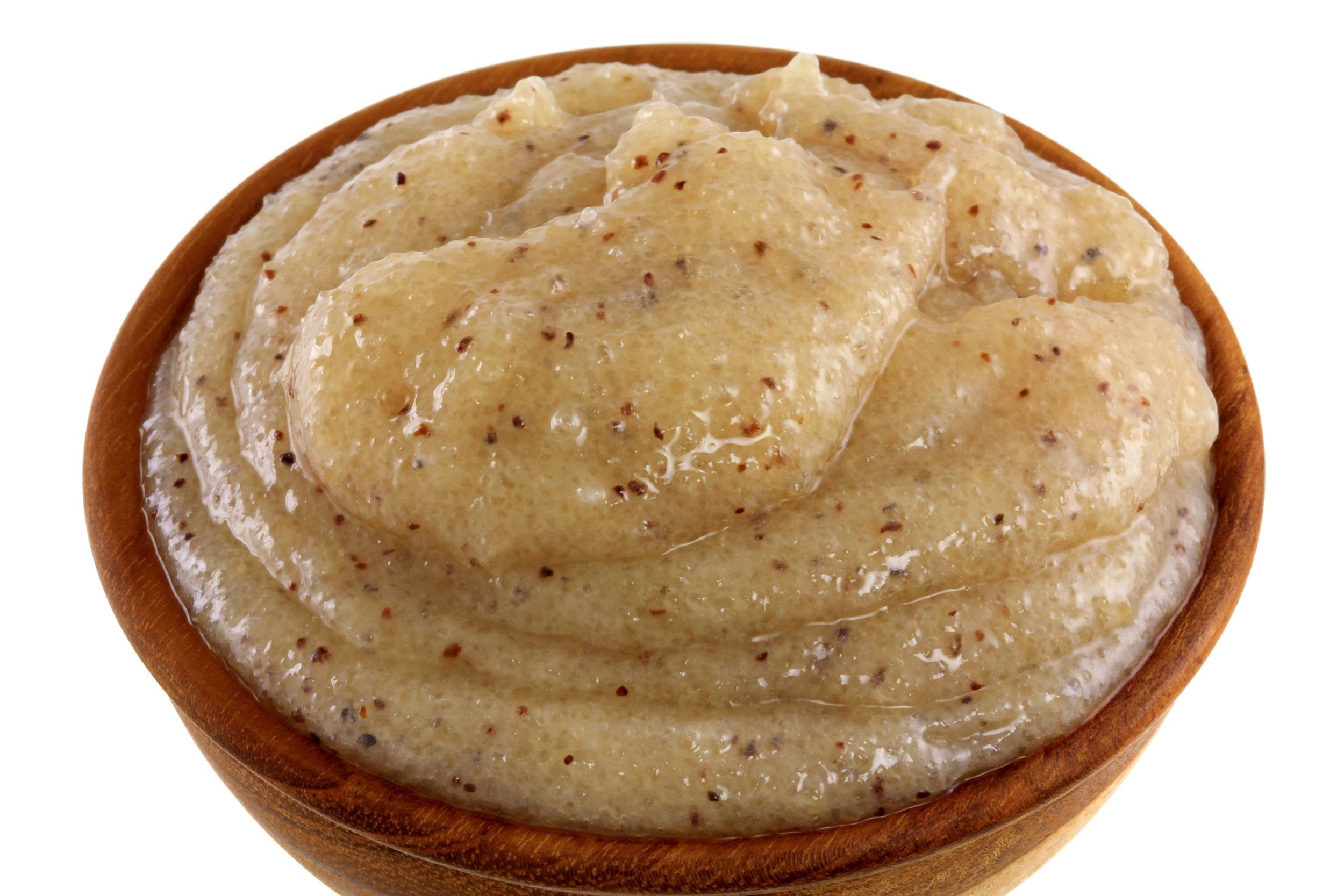 wooden bowl of mashed brown sugar with almond oil and macadamia shell grains