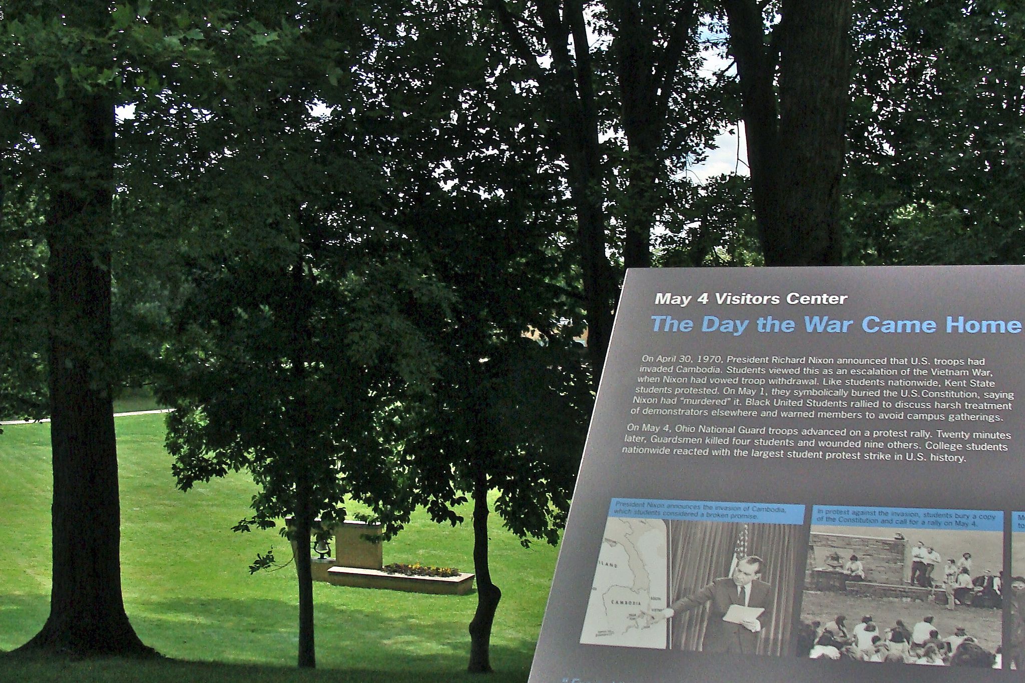 plaque from may visitors center at kent state, trees in background