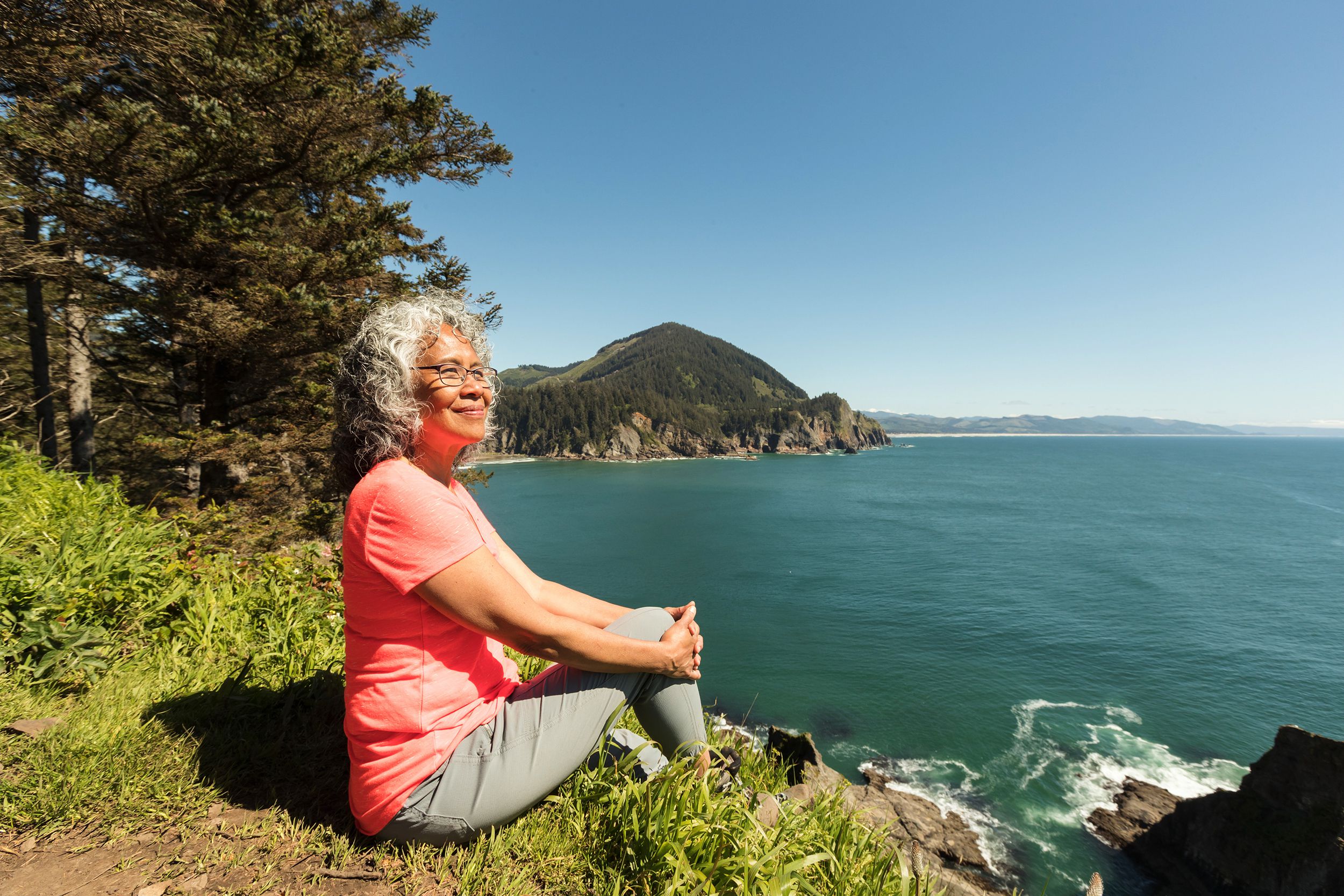 Senior woman sitting on the edge of a lake