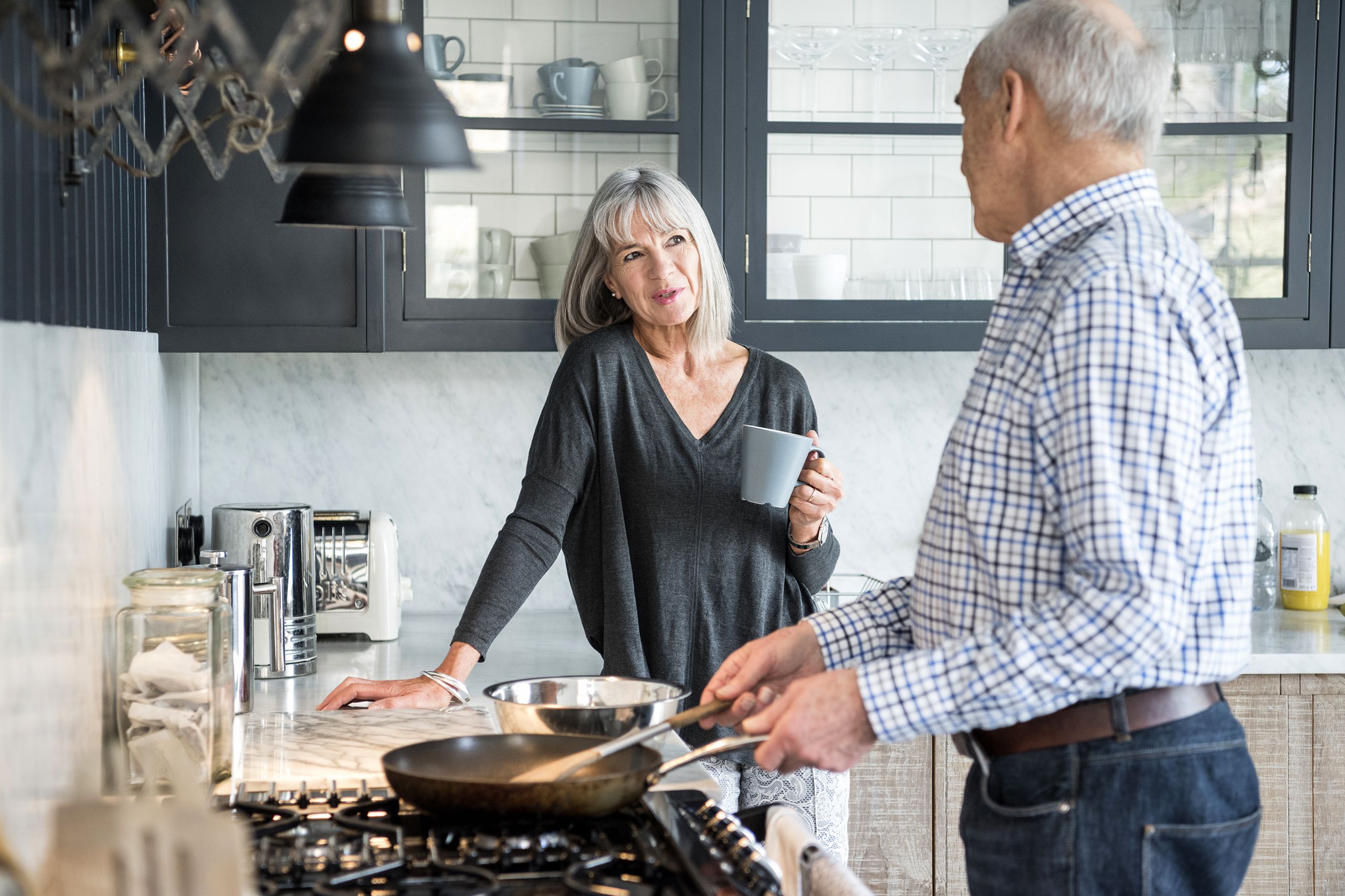 Couple talking and cooking together in the kitchen