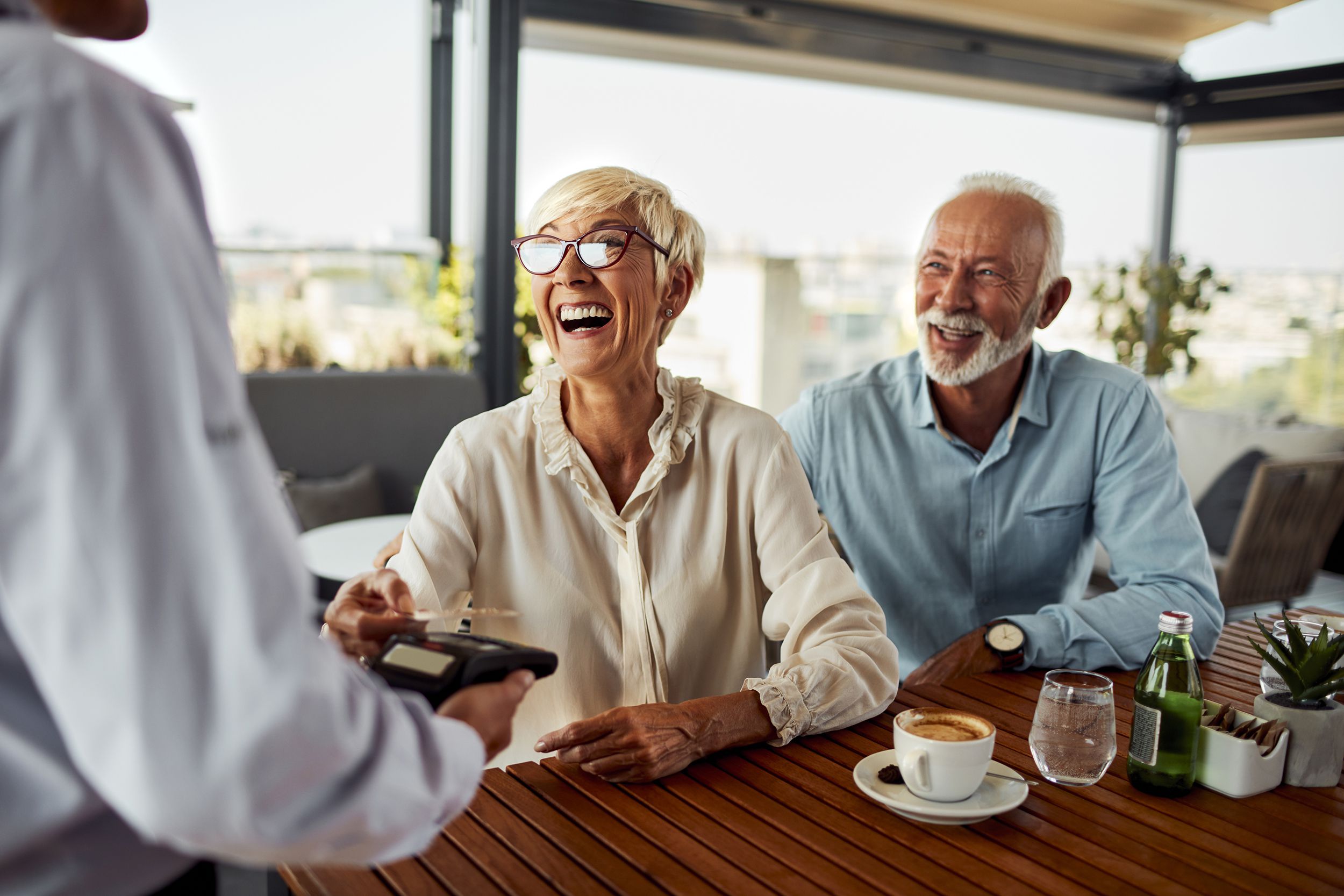 Senior woman paying for a meal at a restaurant