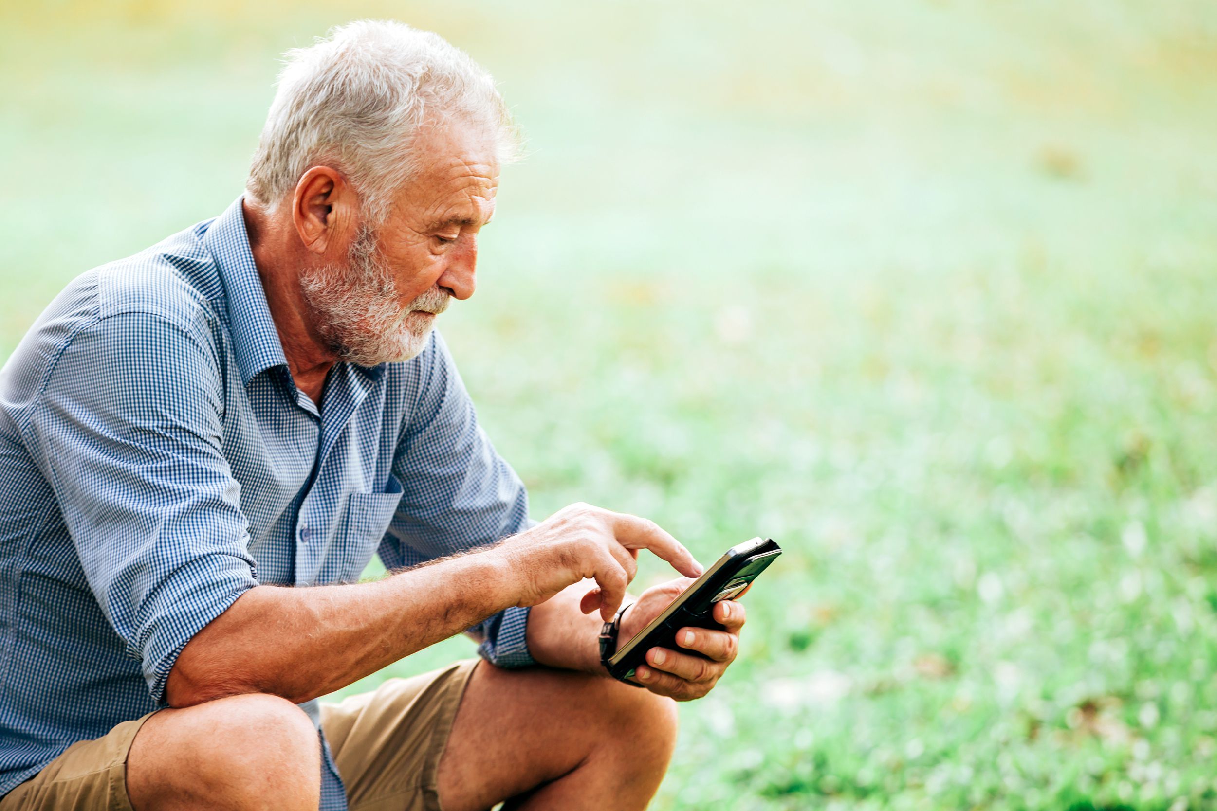 Depressed senior man on his phone outside