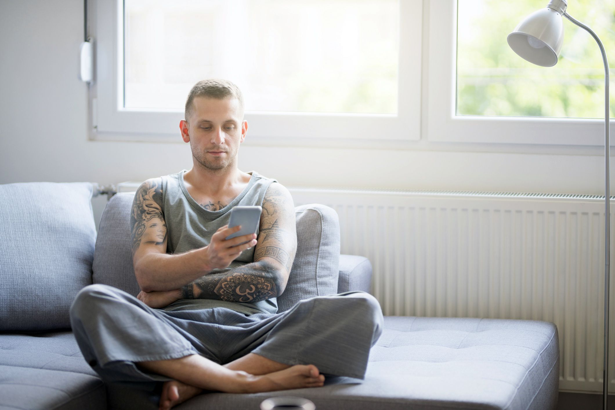 man calmly sitting on couch looking at phone