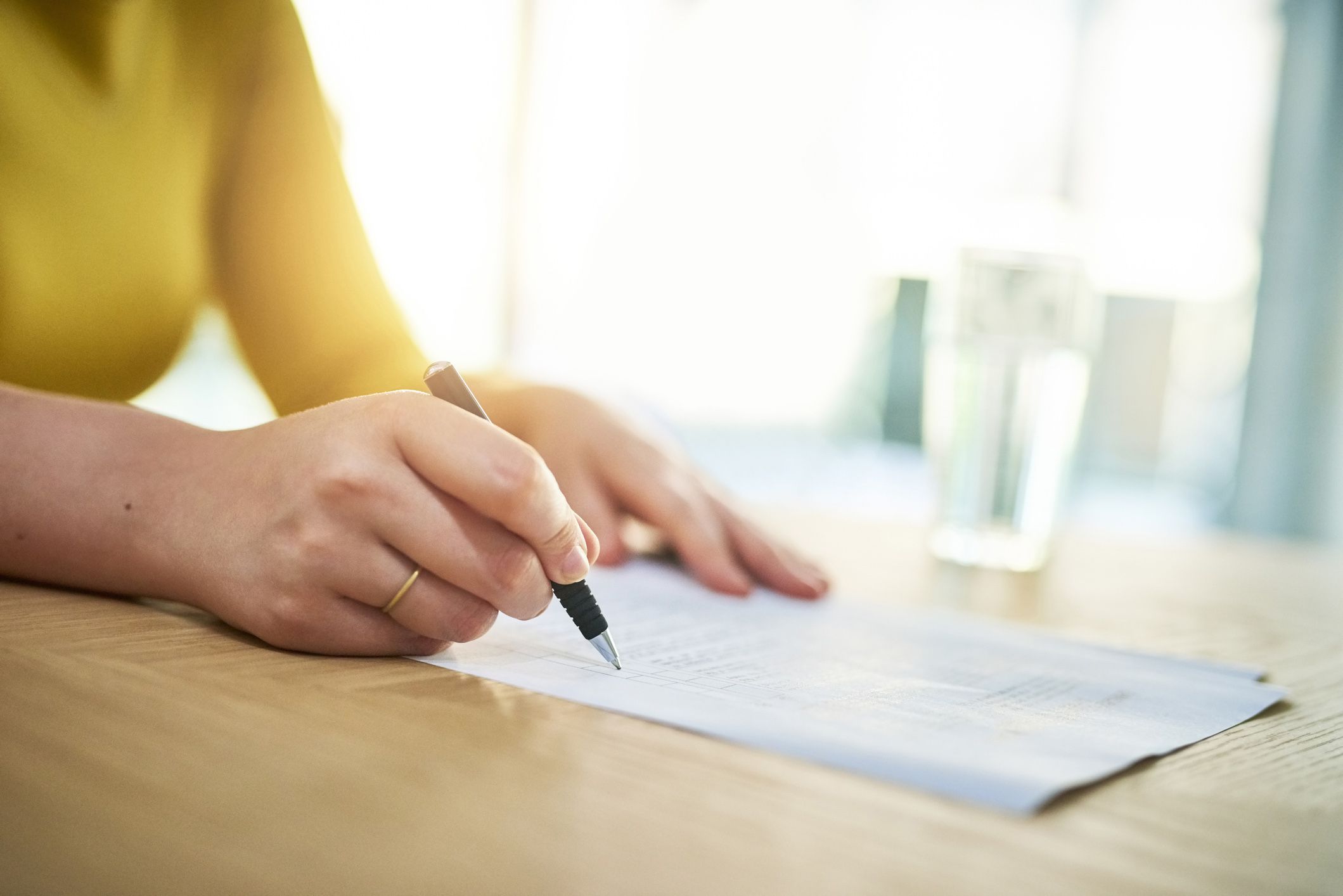 hands holding pen taking test on wooden table