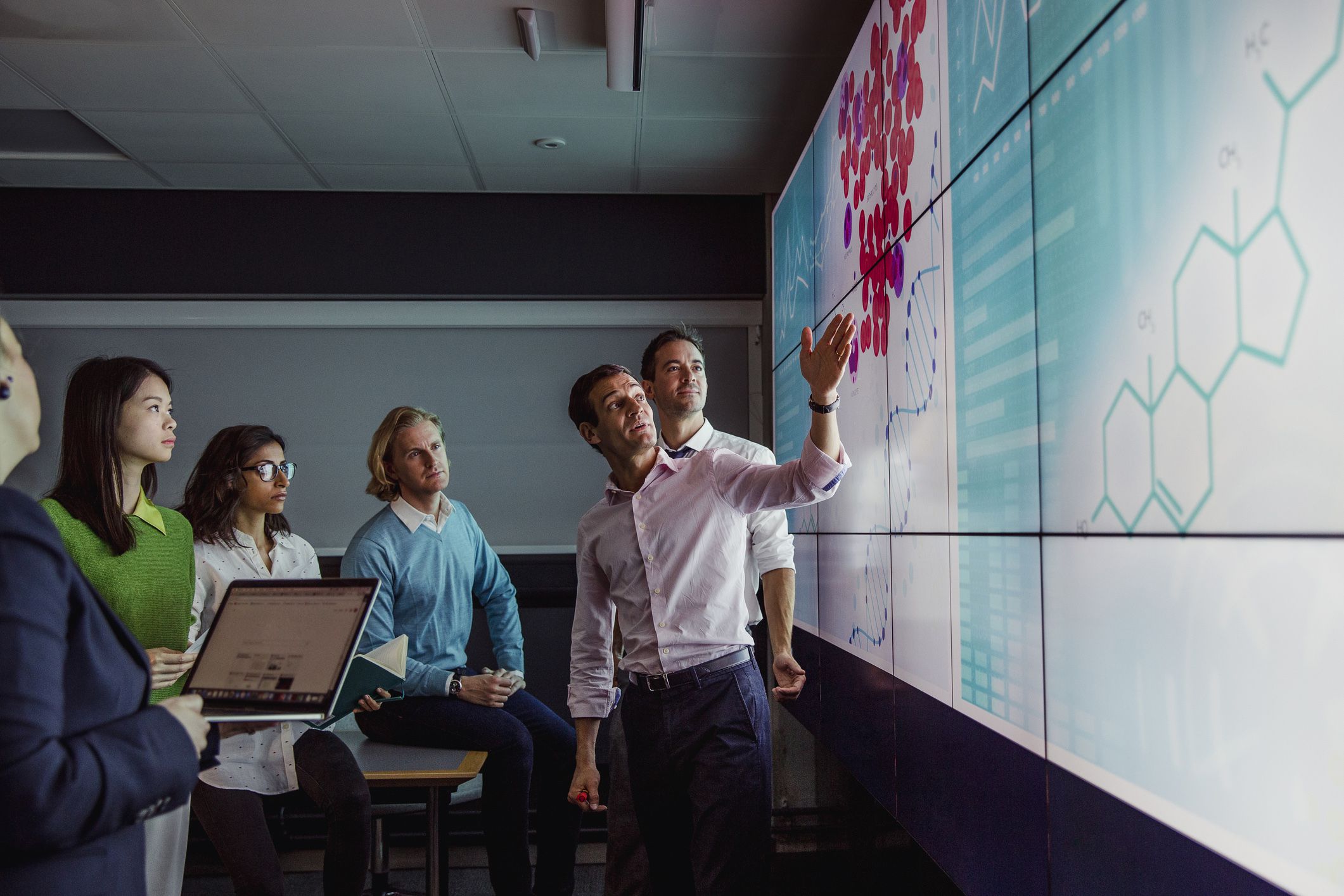 adults viewing screen with medical diagrams and data
