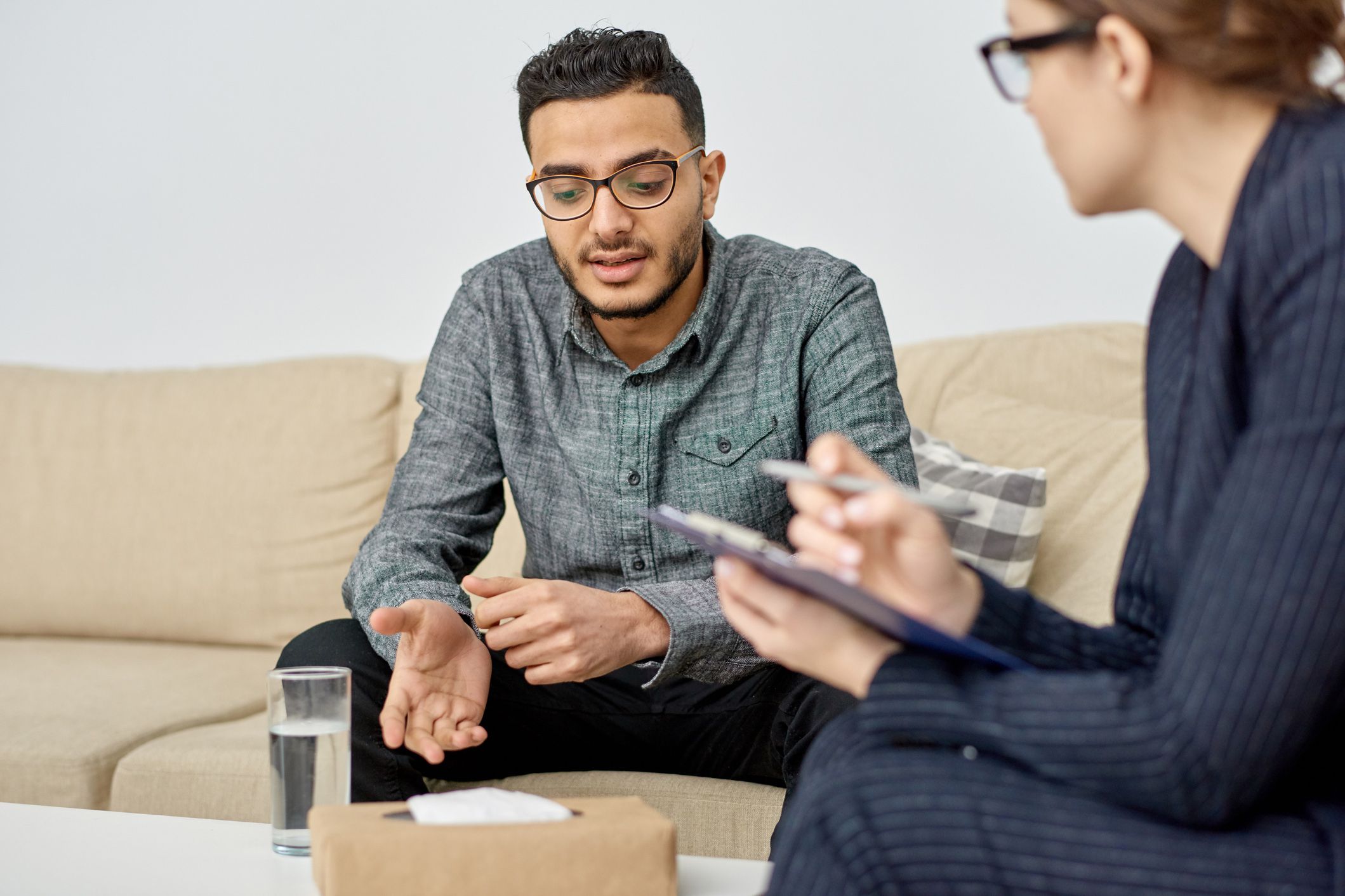 patient sitting on couch talking to therapist