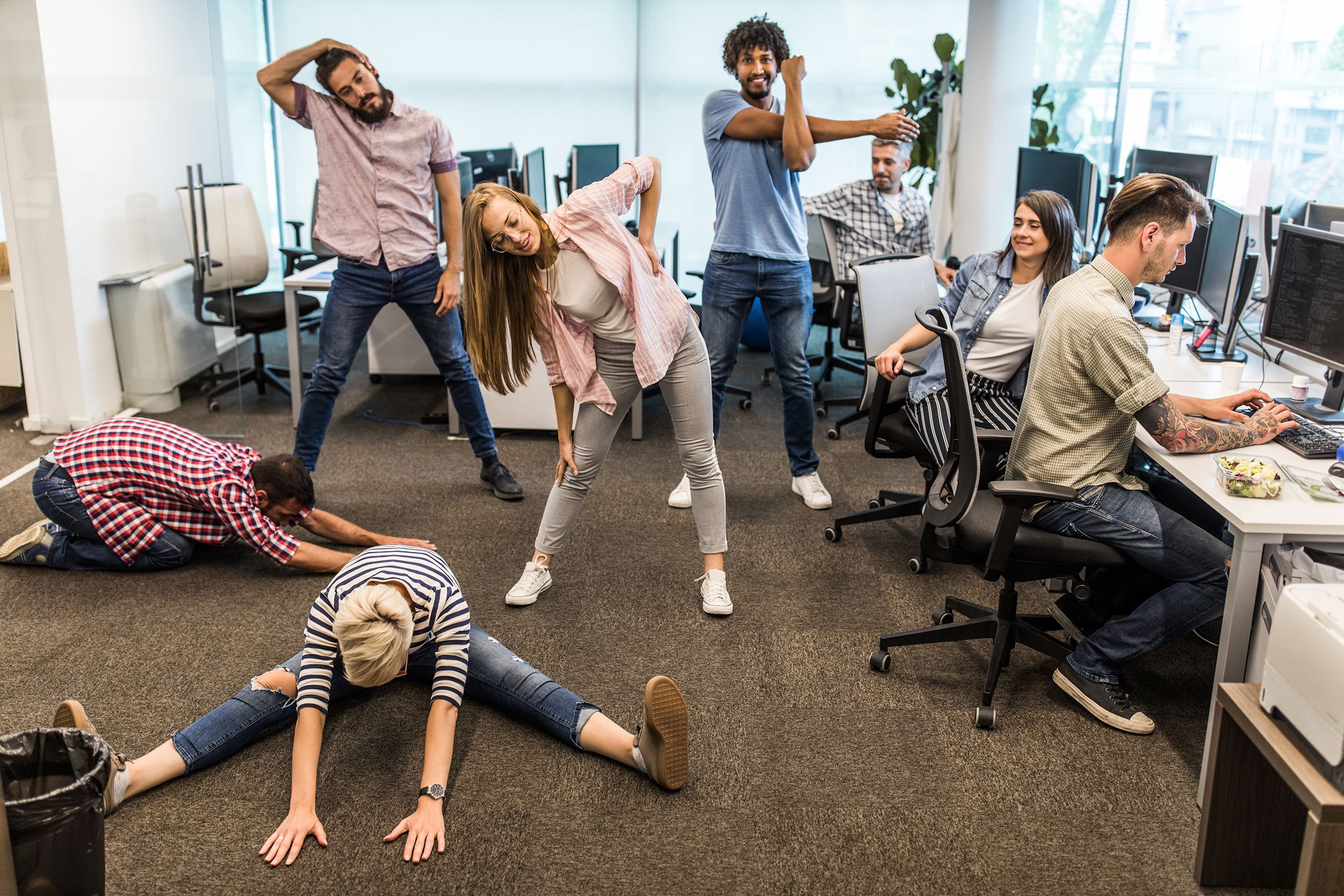 group of programmers exercising on a break in the office