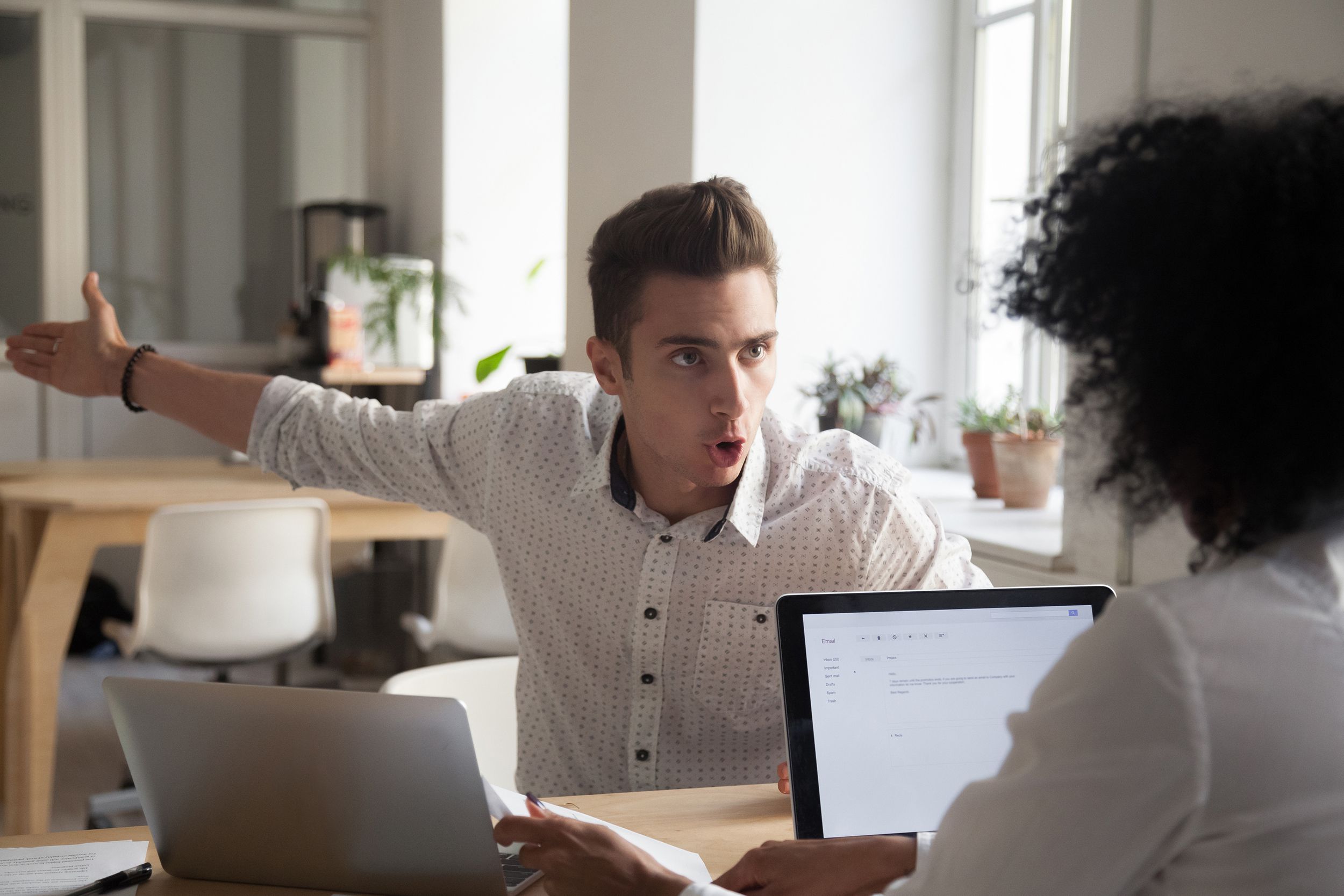 mad male employee blaming female colleague for mistake