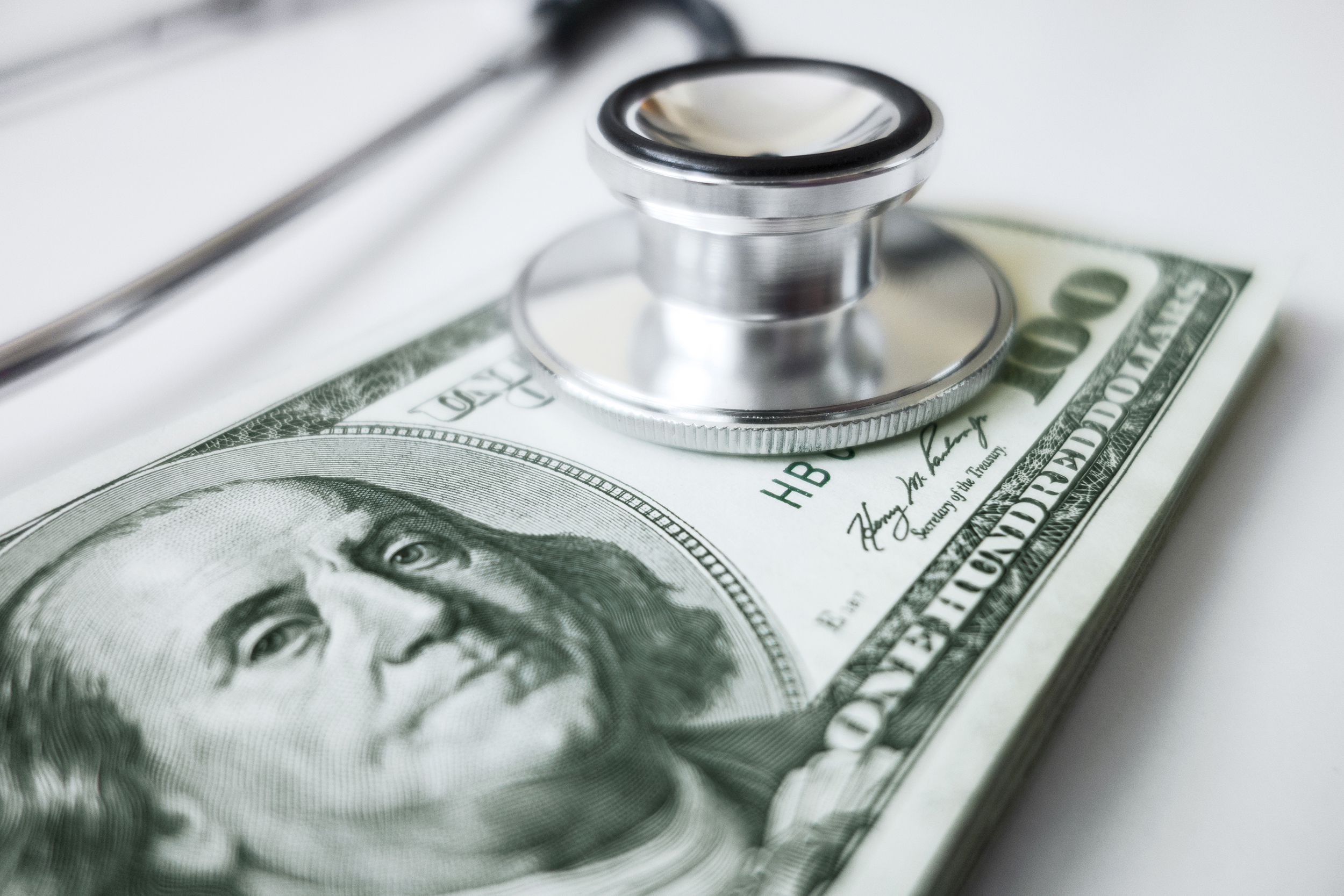 stethoscope on pile of $100 bills